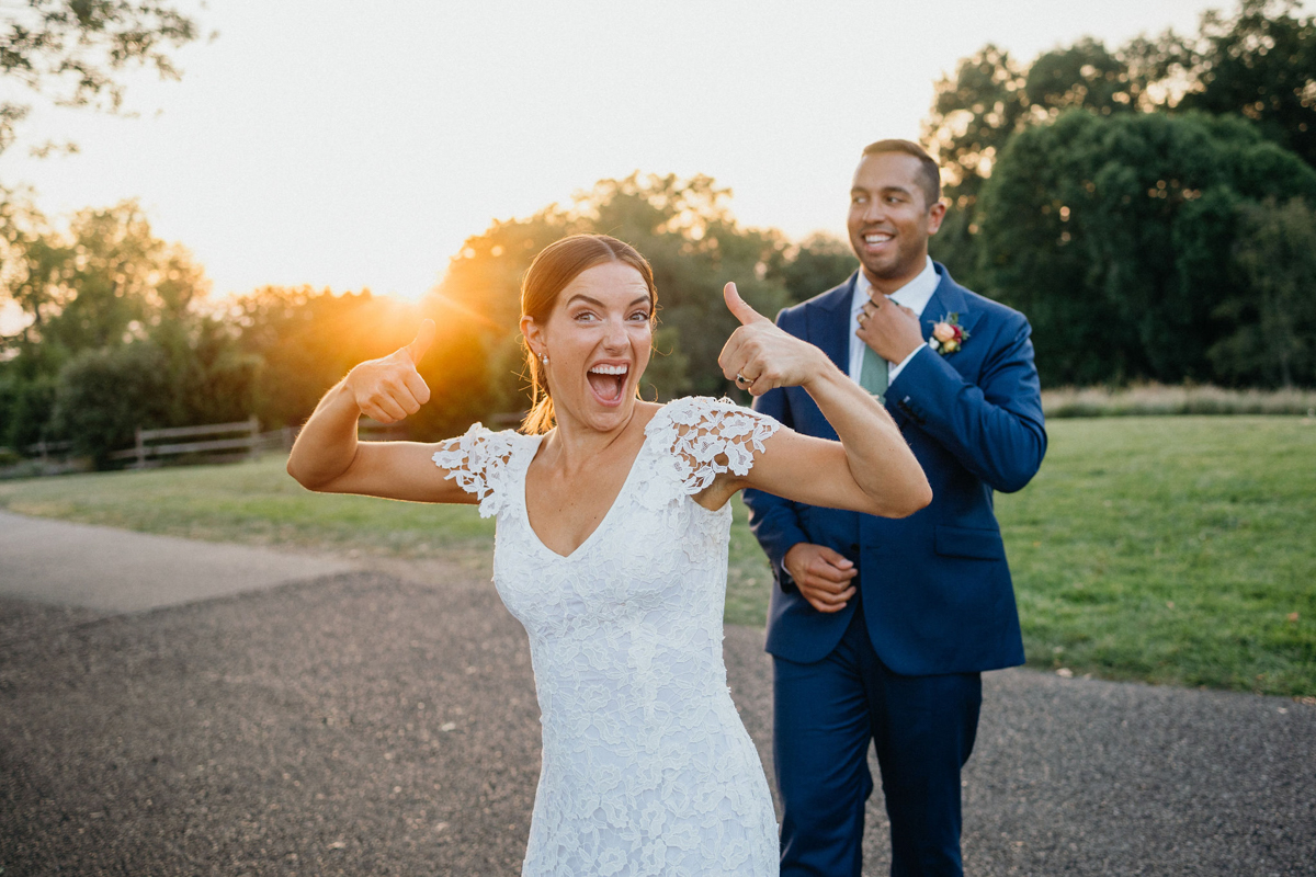 Golden hour candid of bride and groom with their thumbs up. 