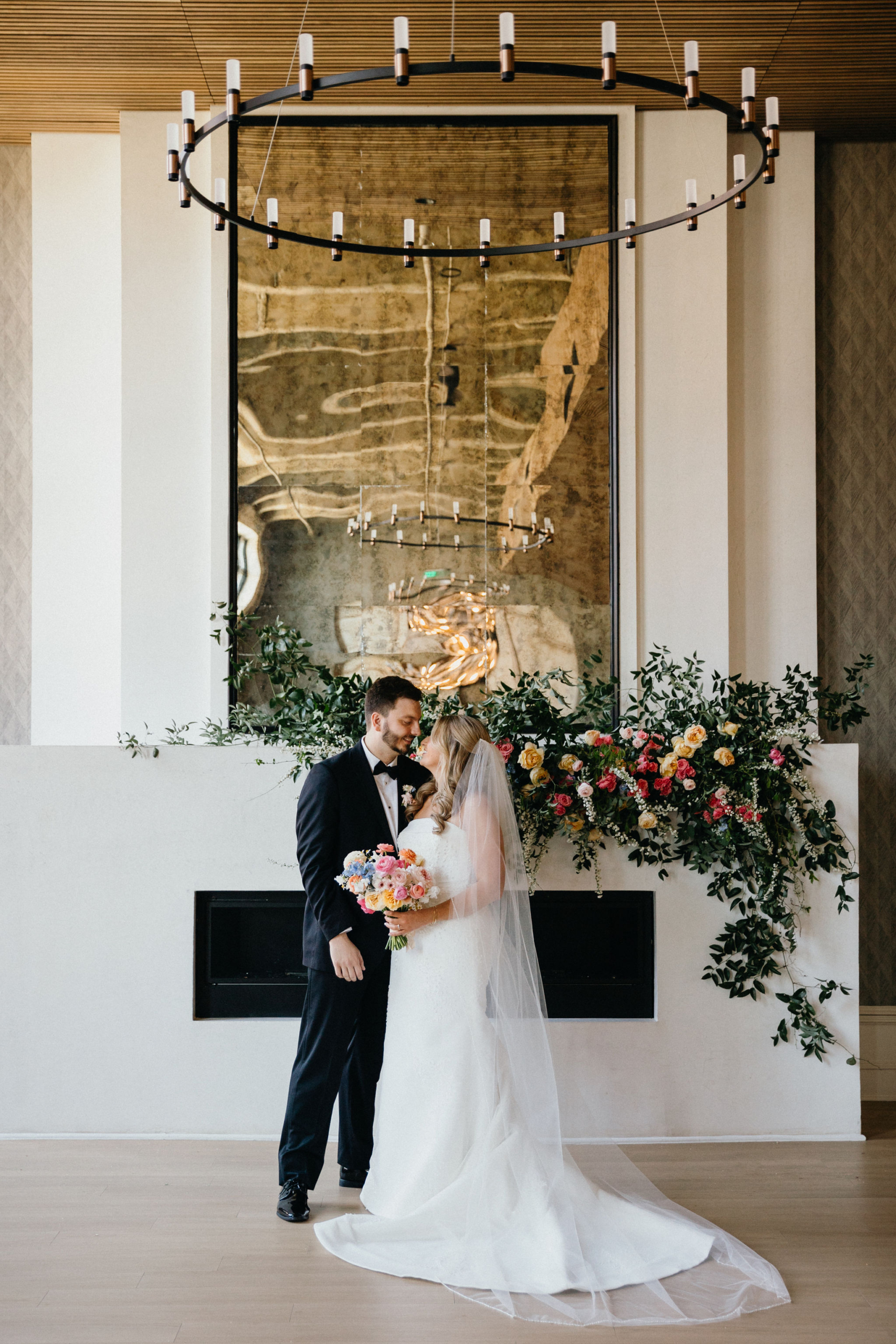 Vibrant spring florals frame the couple at their Philly wedding venue.