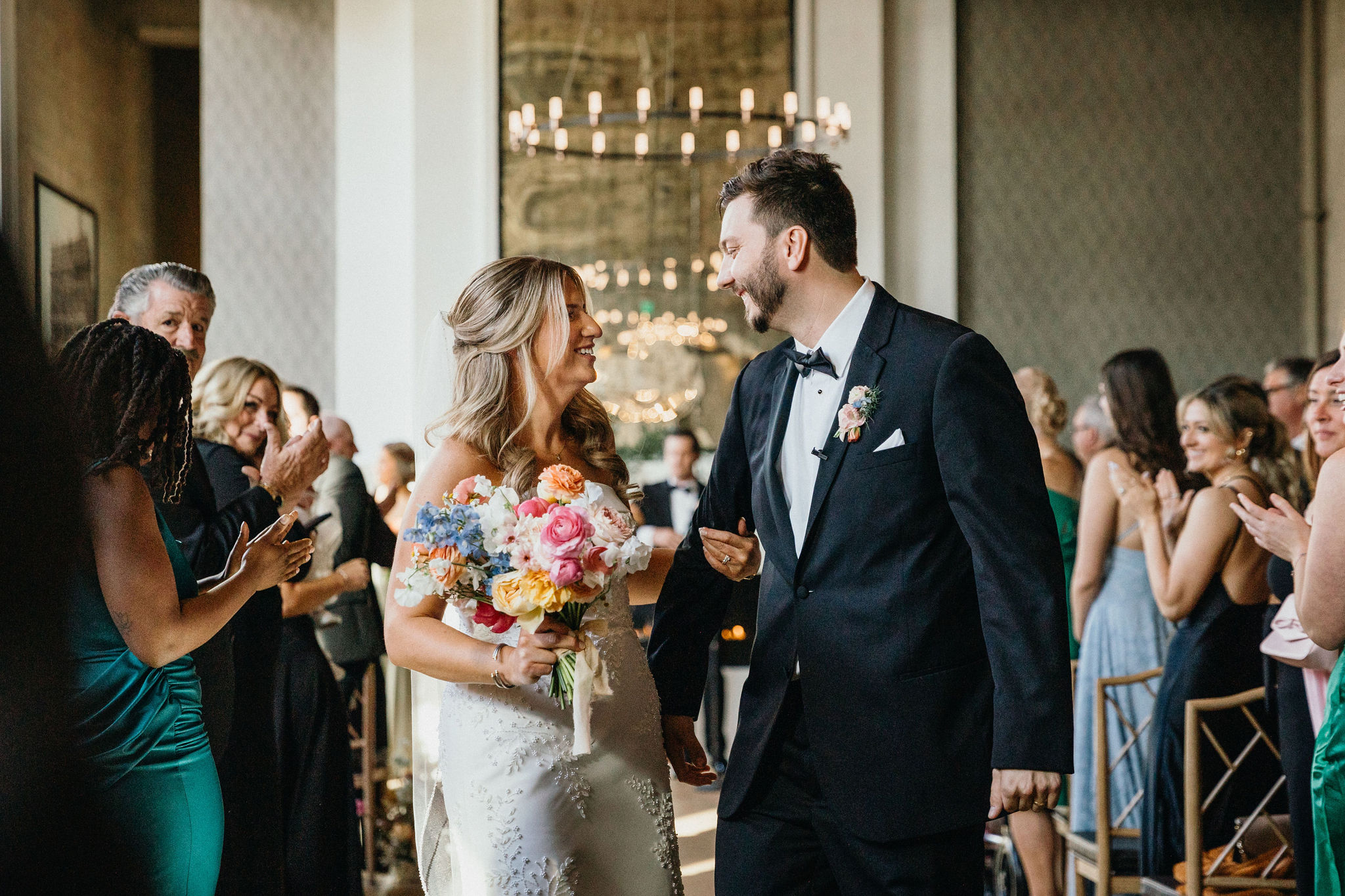 The couple exchanges vows under a floral arch.