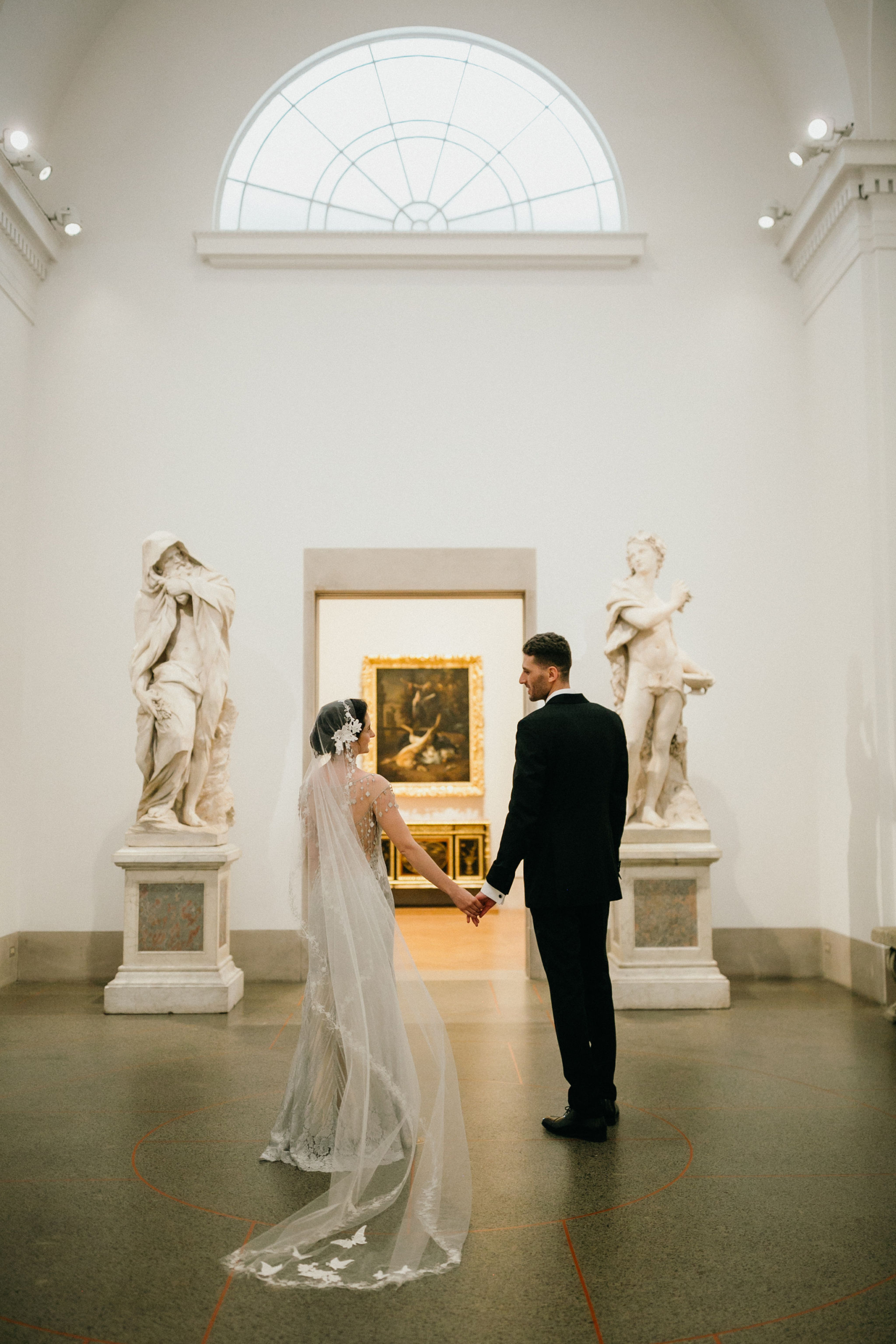 A wedding couple poses in an iconic museum setting in Philadelphia.