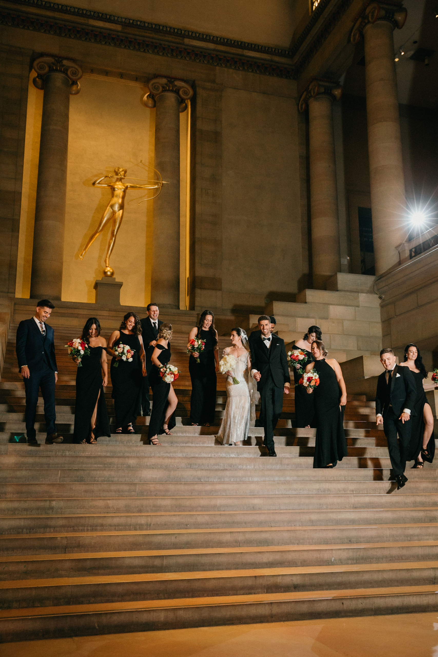 A joyful wedding moment set against a striking architectural backdrop.