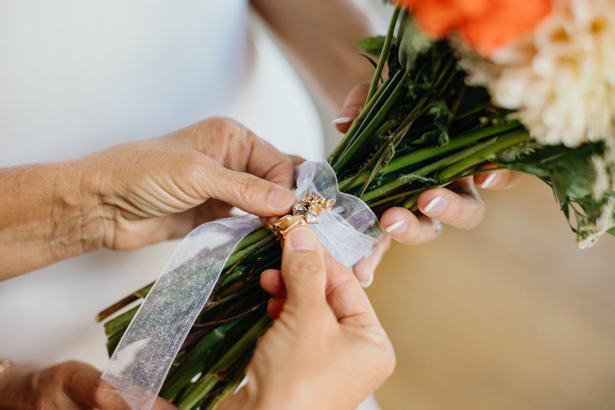 Charm on bride's bouquet honoring her late family member.