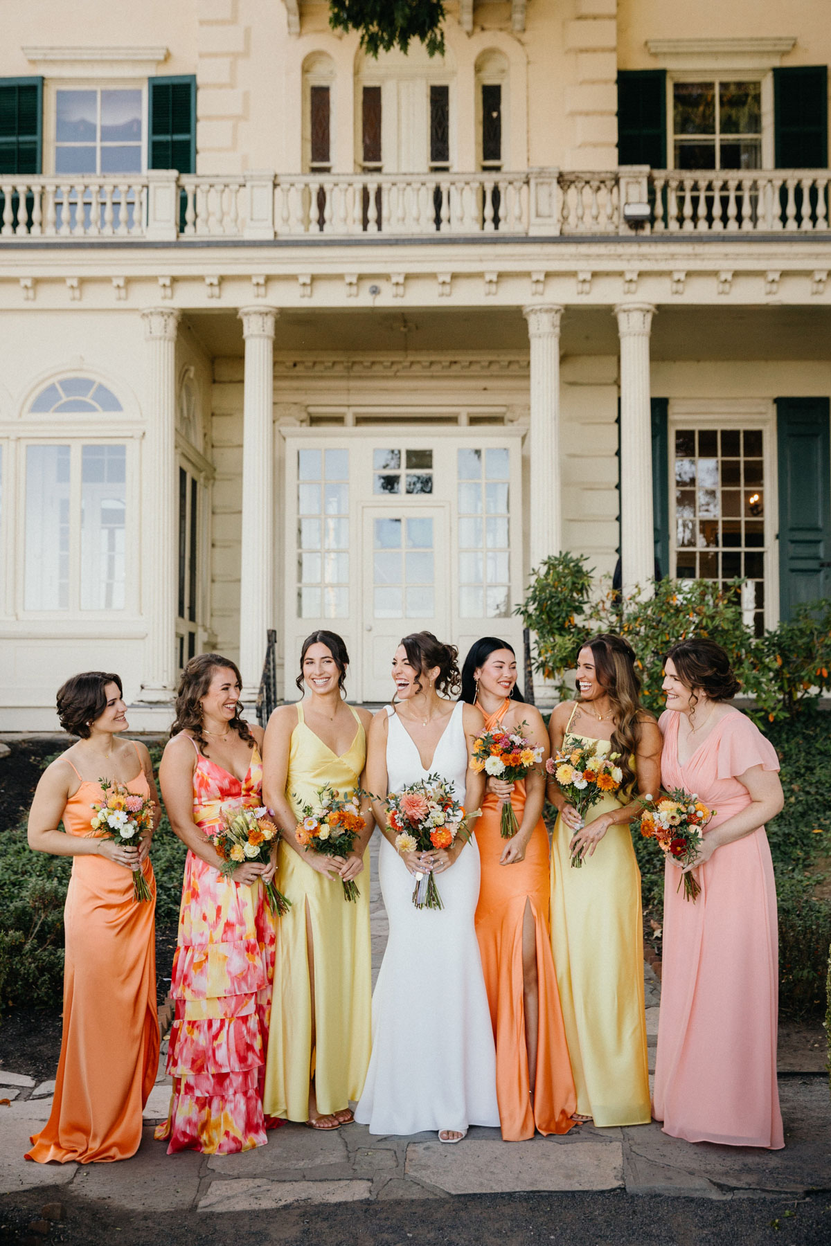 Mismatch bridesmaid dresses in sunset tones.