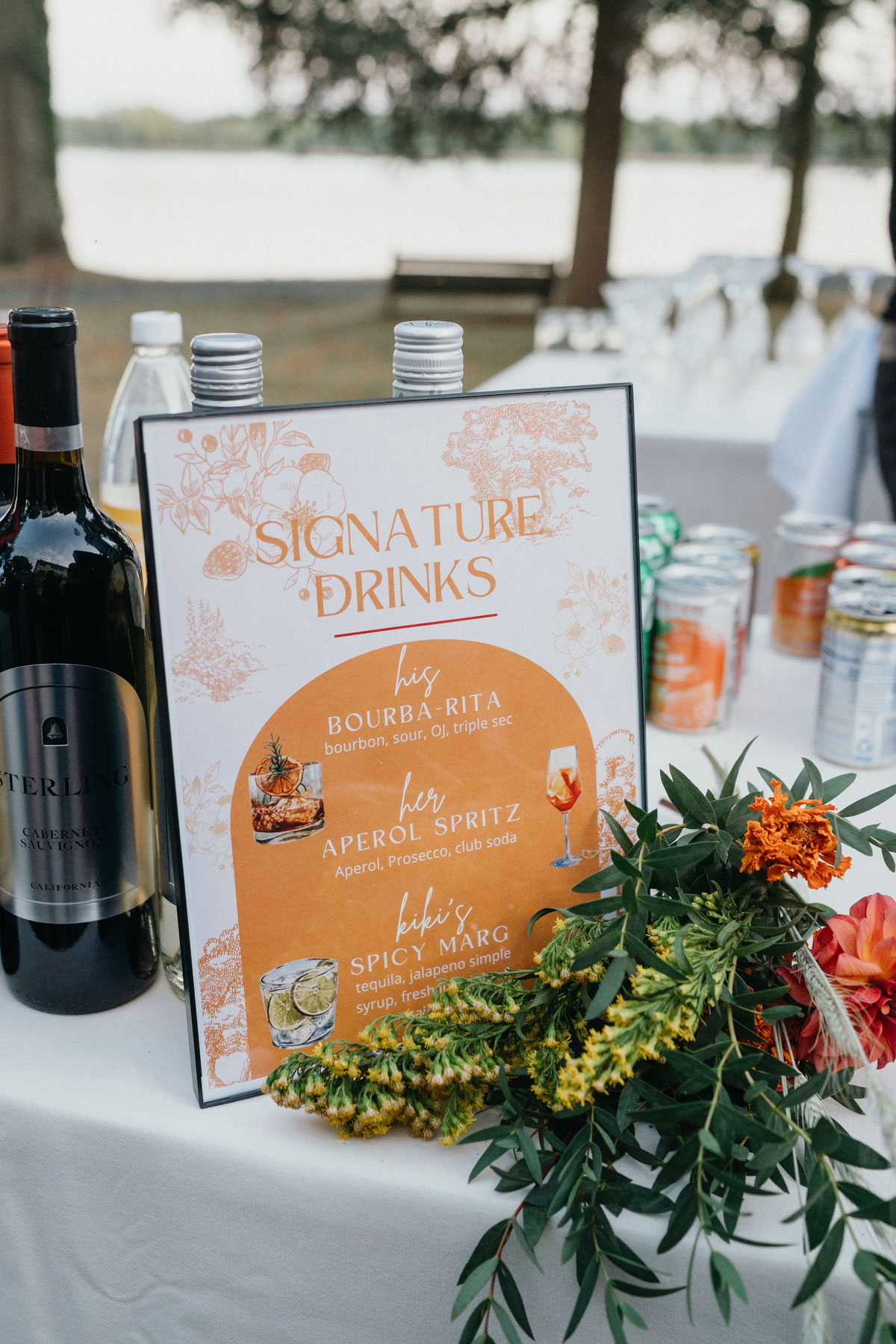 Signature drink signage on a wedding reception bar table.