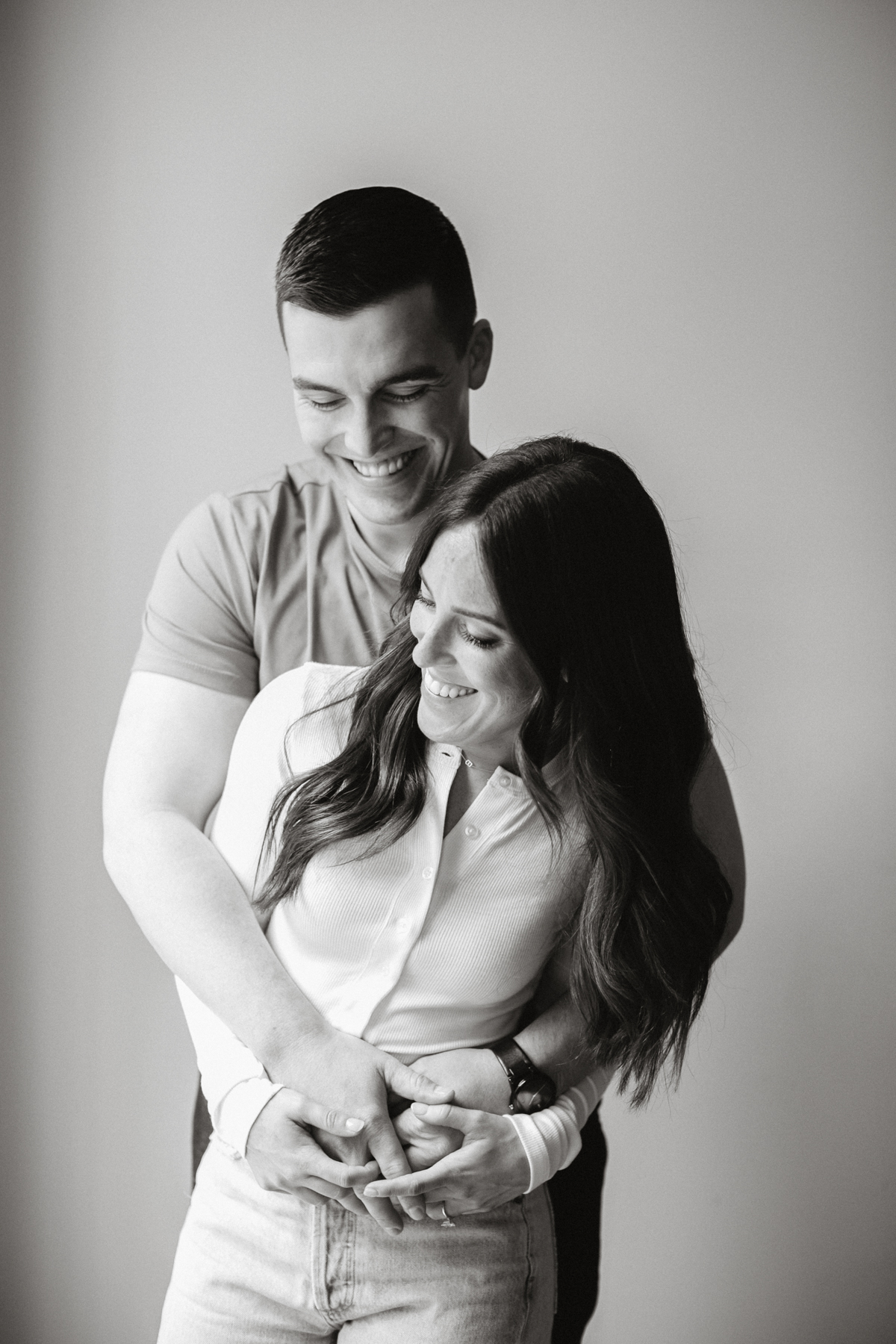 A couple poses in a modern, stylishly decorated rented space, with soft lighting highlighting their smiles.