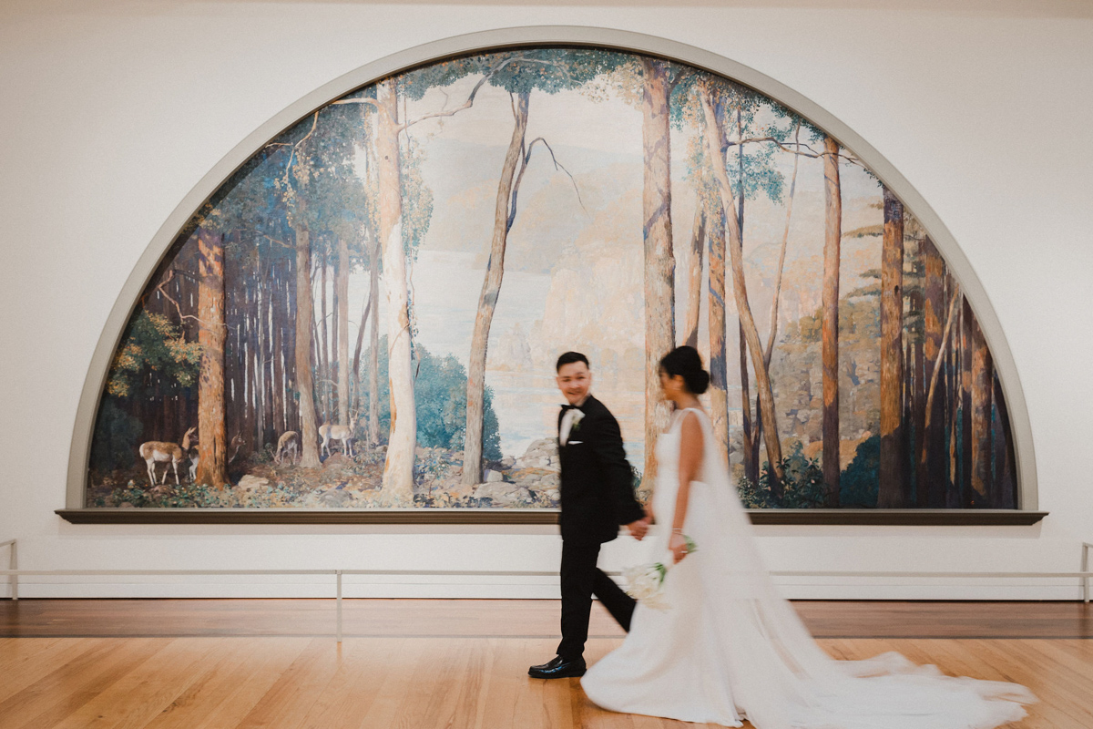 Newlyweds walk hand in hand through the galleries of the Michener Museum, surrounded by art.