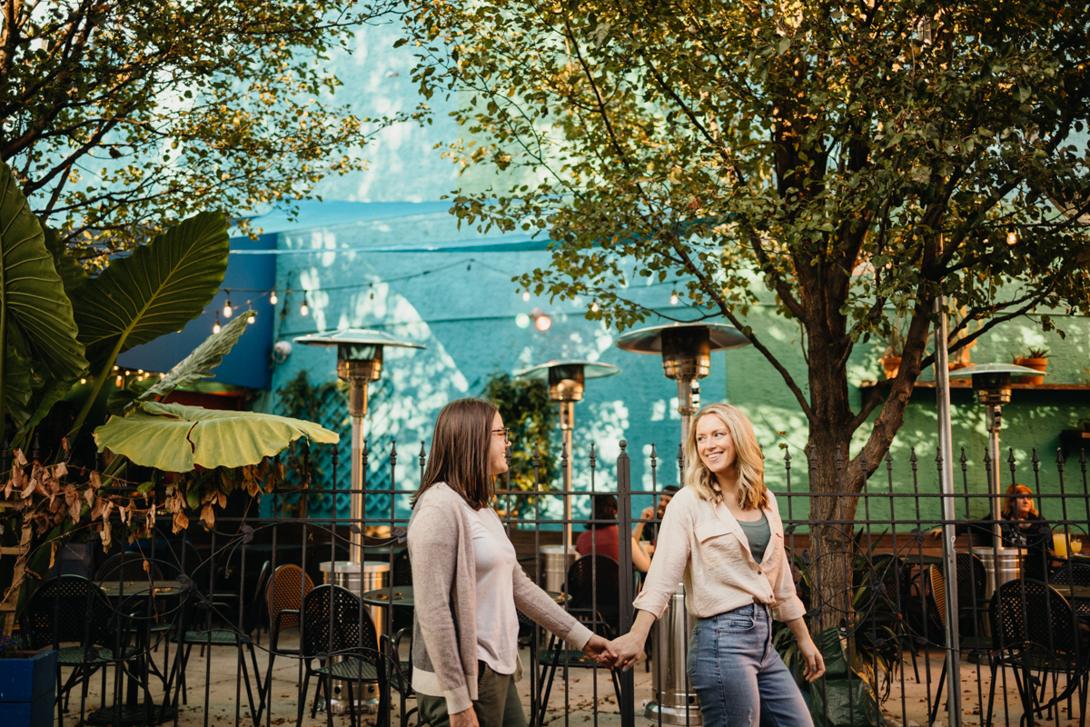 A couple embraces near a colorful mural in South Philadelphia, adding a vibrant touch to their photos.