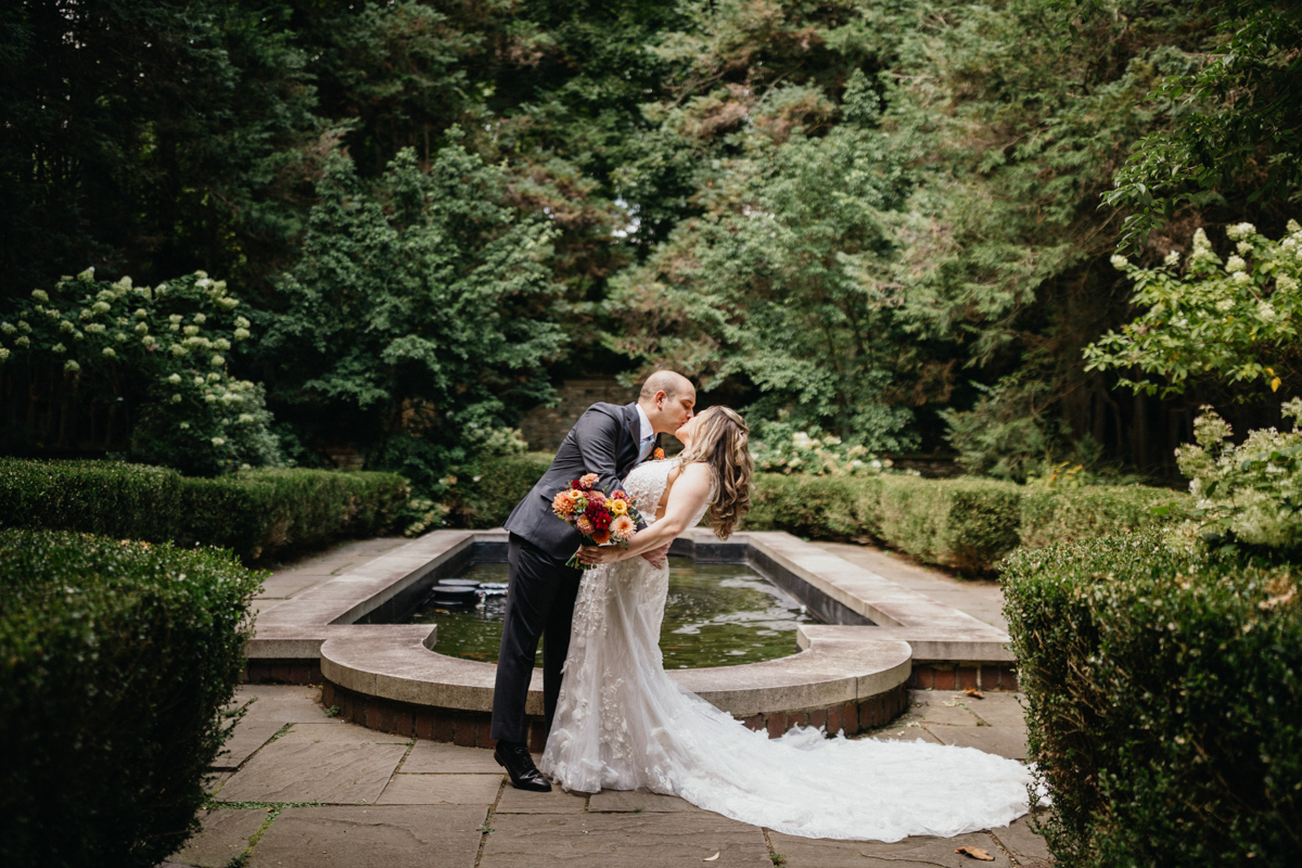 A historic estate with a fountain-lined pathway leading to a romantic ceremony spot.