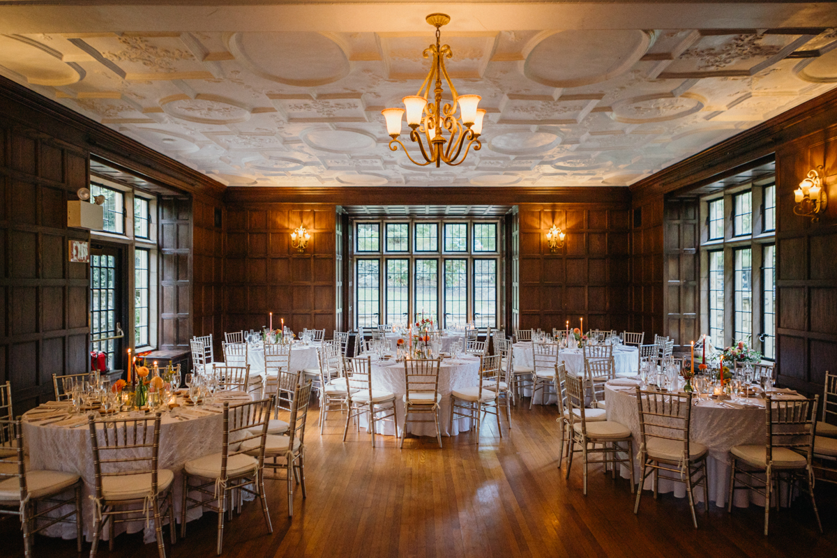 Estate wedding venue with a grand ballroom and gilded mirrors reflecting candlelight.