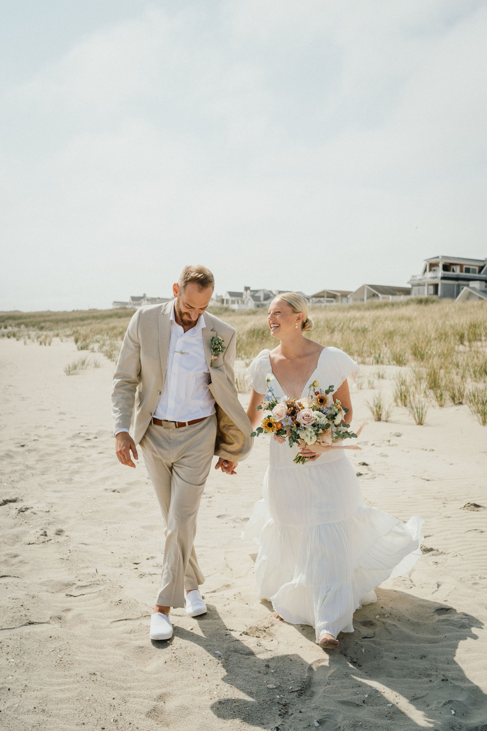 Couple holding hands, looking out at the water.