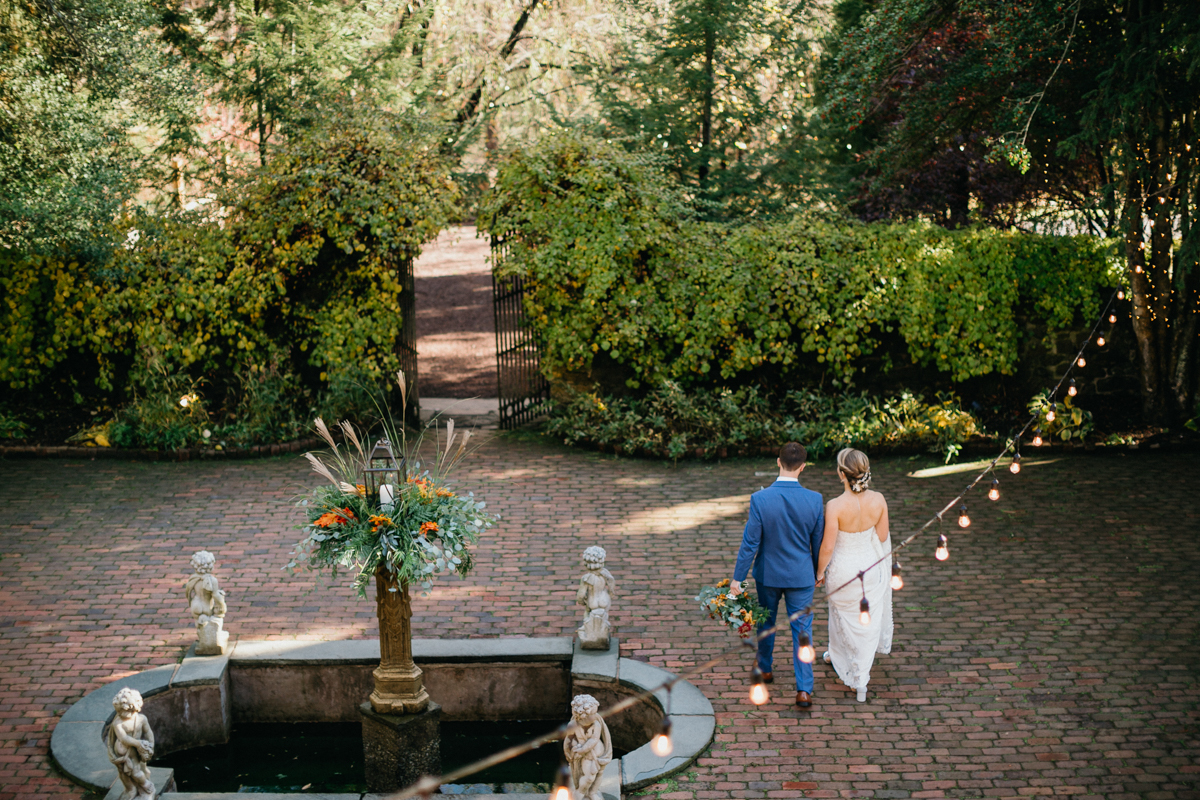 Estate wedding venue featuring historic stone walls and a sweeping staircase.