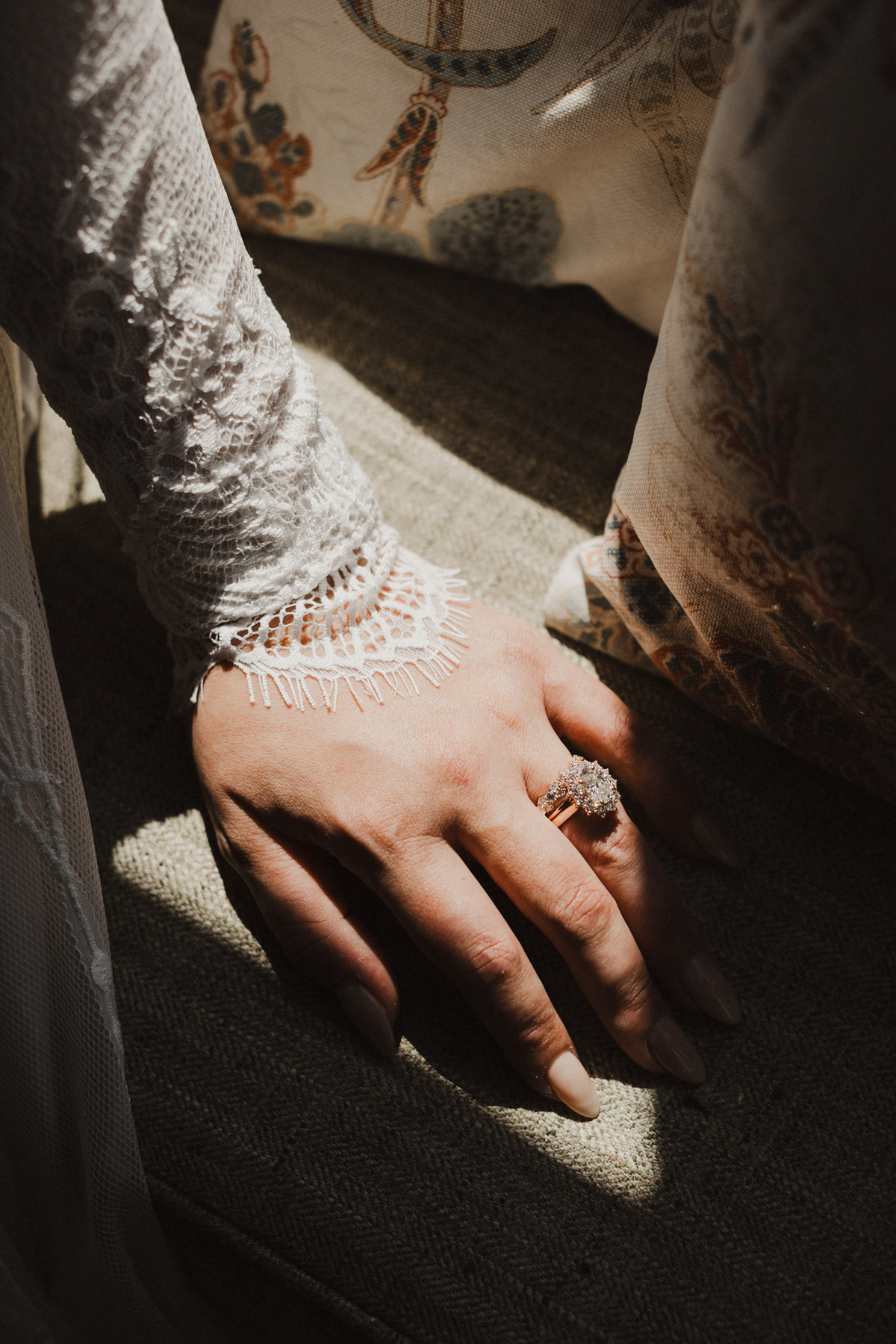 Sun sparkling on vintage engagement ring at rustic wedding venue.