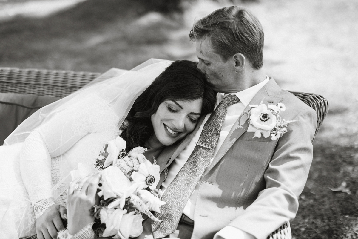 The newlyweds wrapped in a cozy vintage blanket during golden hour.