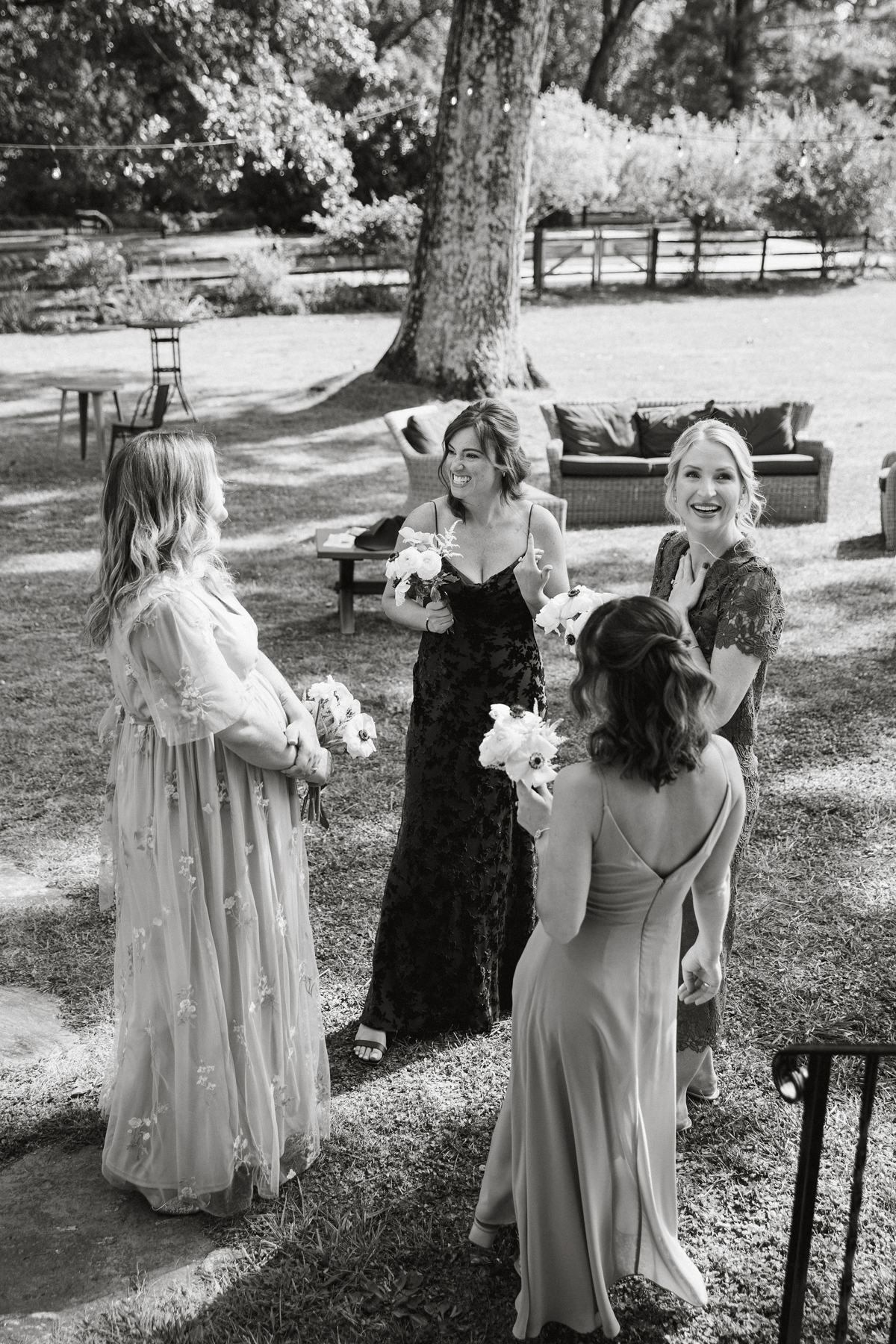 The wedding party walking together through the vineyard, laughing and chatting.