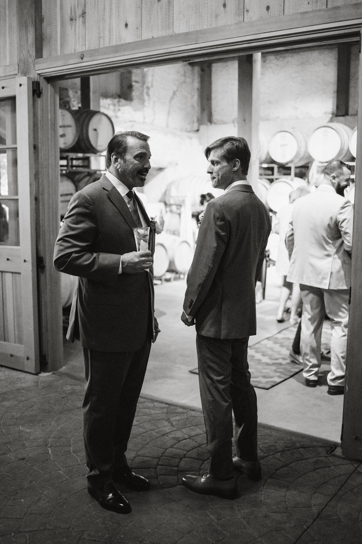 Candid black and white in wine cellar wedding venue. 