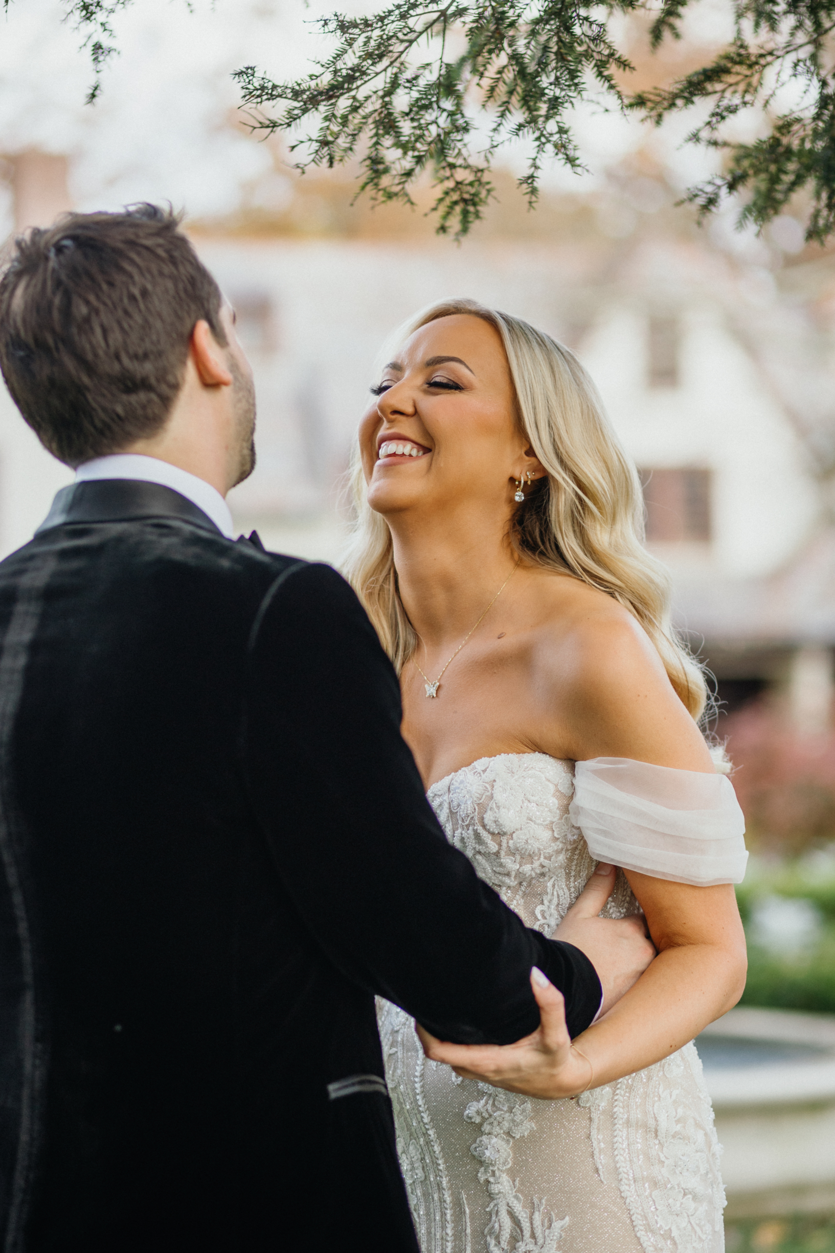 A couple embraces on the lush grounds surrounded by greenery shot by Philadelphia wedding photographer.