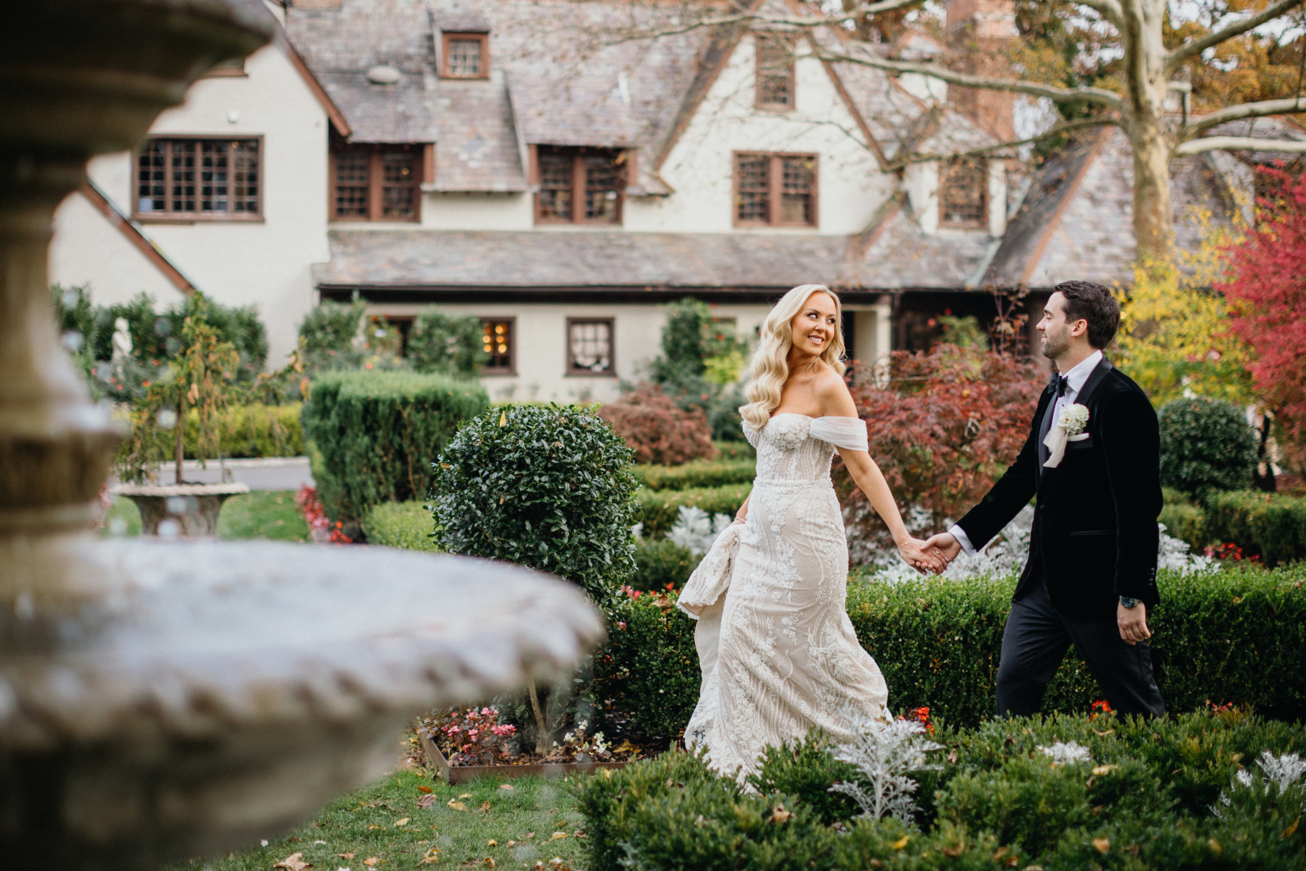 Newlyweds stroll hand in hand across the picturesque grounds of their Hotel Du Village wedding.