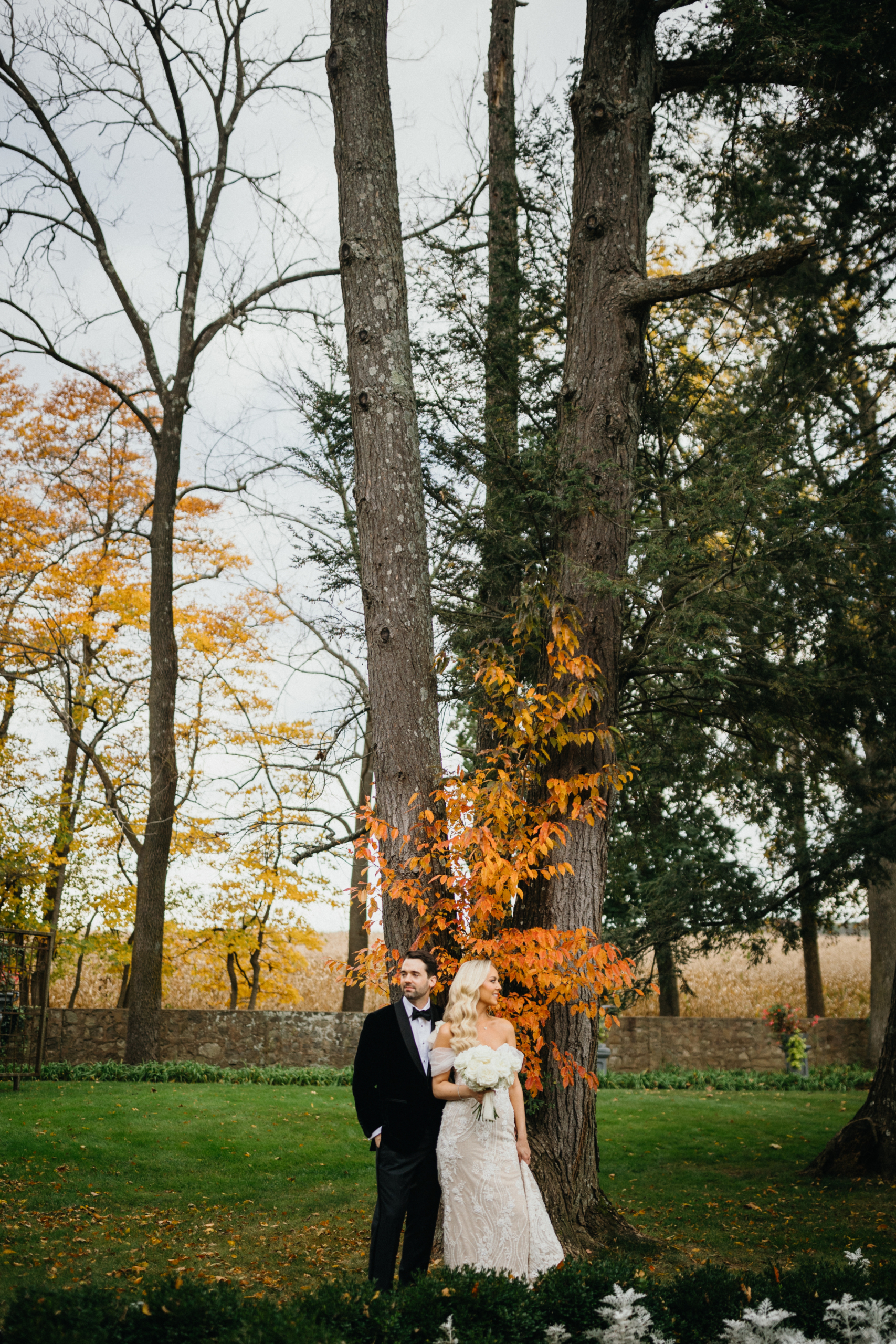 The couple stands beneath towering trees at Hotel Du Village wedding, soaking in the day captured by Philadelphia wedding photographer.