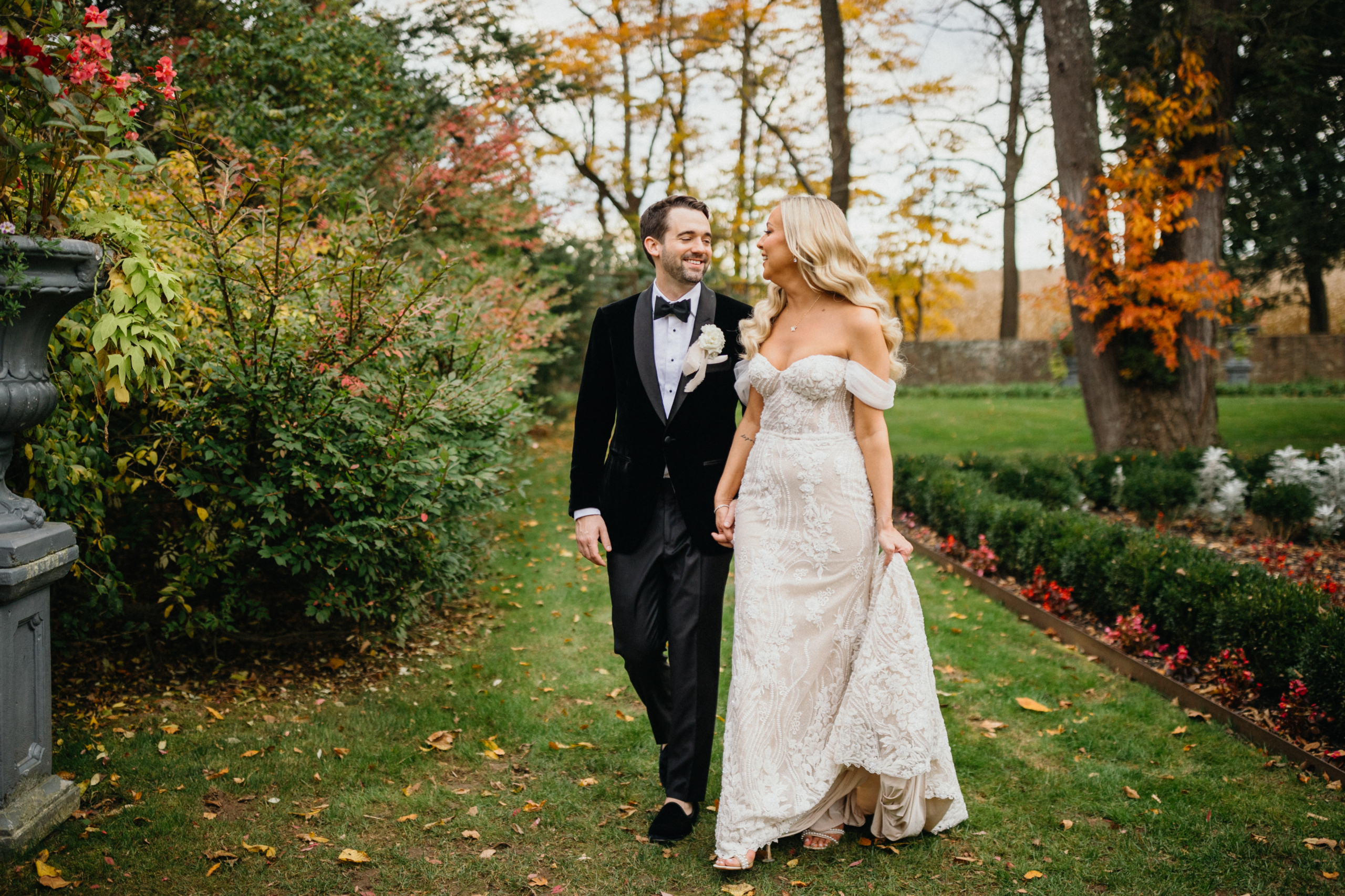 Holding hands, the couple walks along a garden path at their Hotel Du Village wedding.