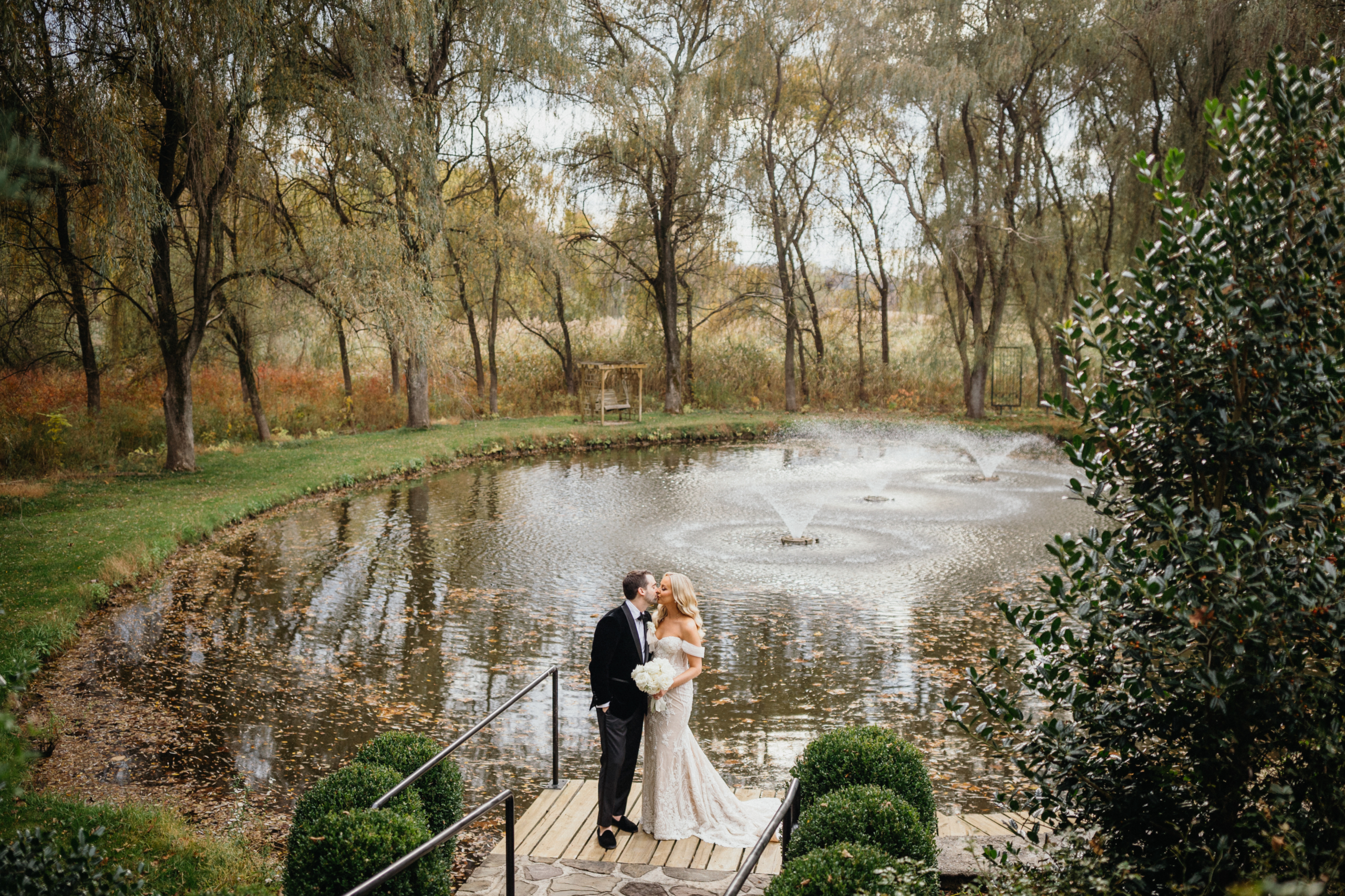 candid kiss in the garden at Hotel Du Village wedding, framed by blooming flowers shot by Philadelphia wedding photographer.