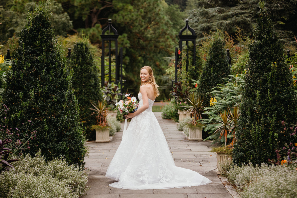 Bride in front of scenic garden landscape at a garden wedding venue in Philadelphia.