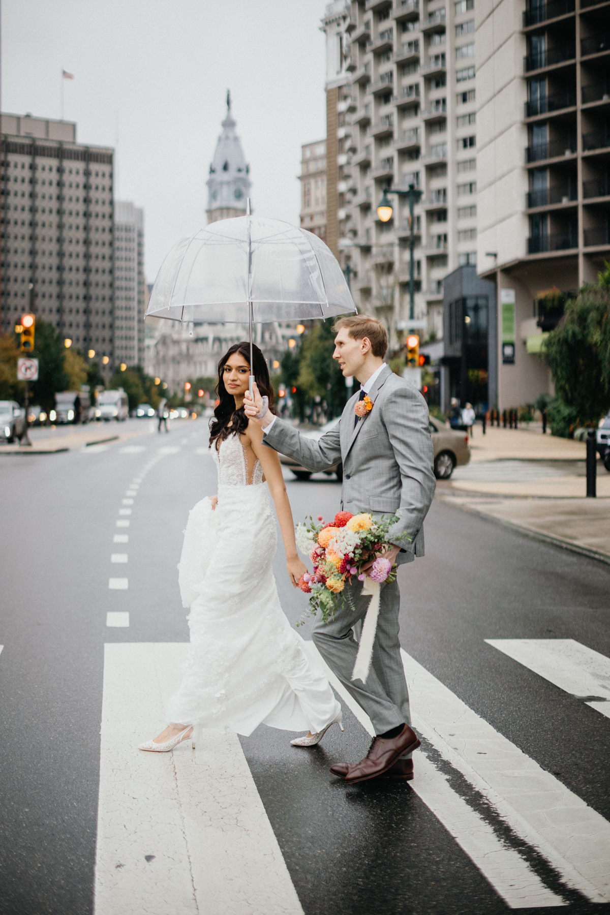 wedding couple crossing the street in front of city hall in Philadelphia