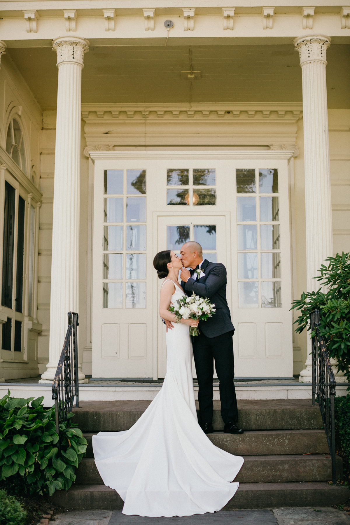 Couple framed by mansion columns – timeless wedding photography