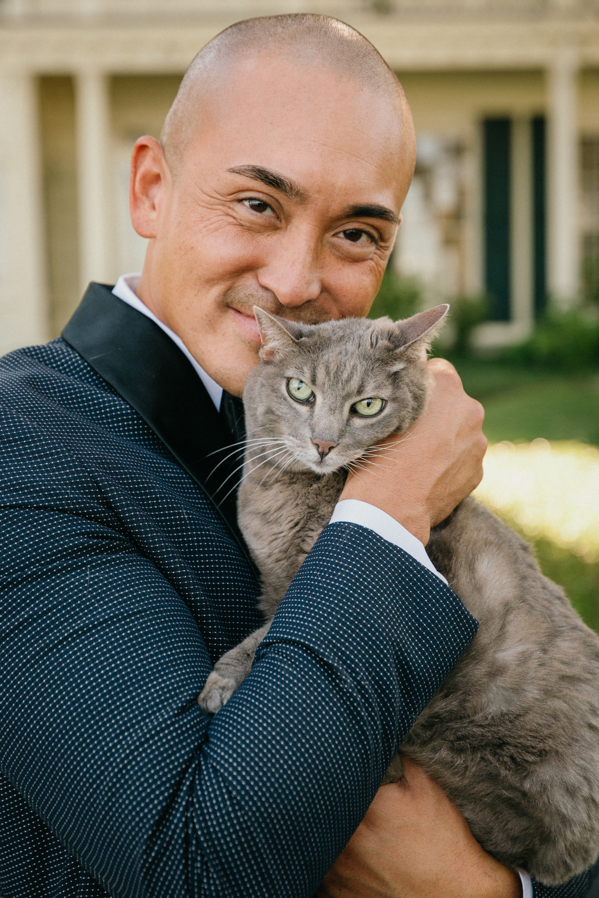 Groom holding wedding cat on Glen Foerd lawn – cat ring bearer at Philadelphia wedding