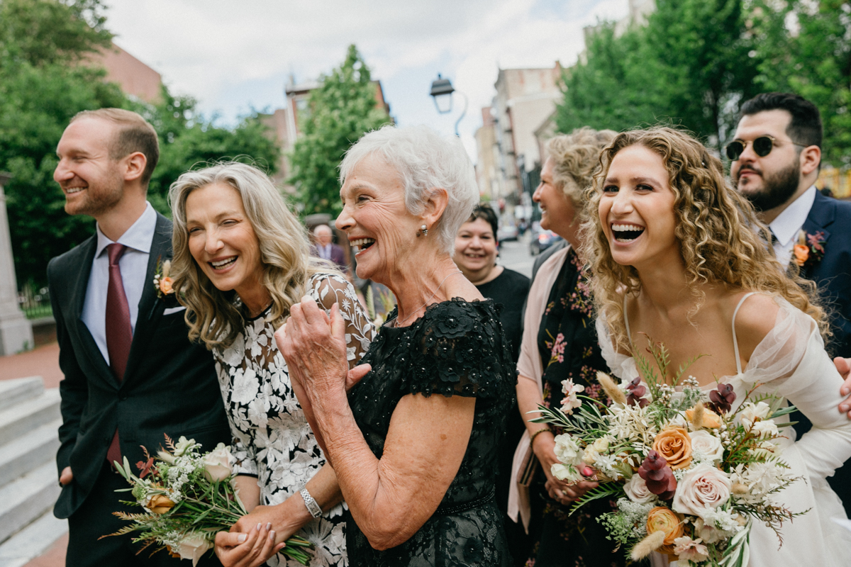 Couple surrounded by smiling friends at the First Bank – Zahav wedding in Philadelphia, candid photography