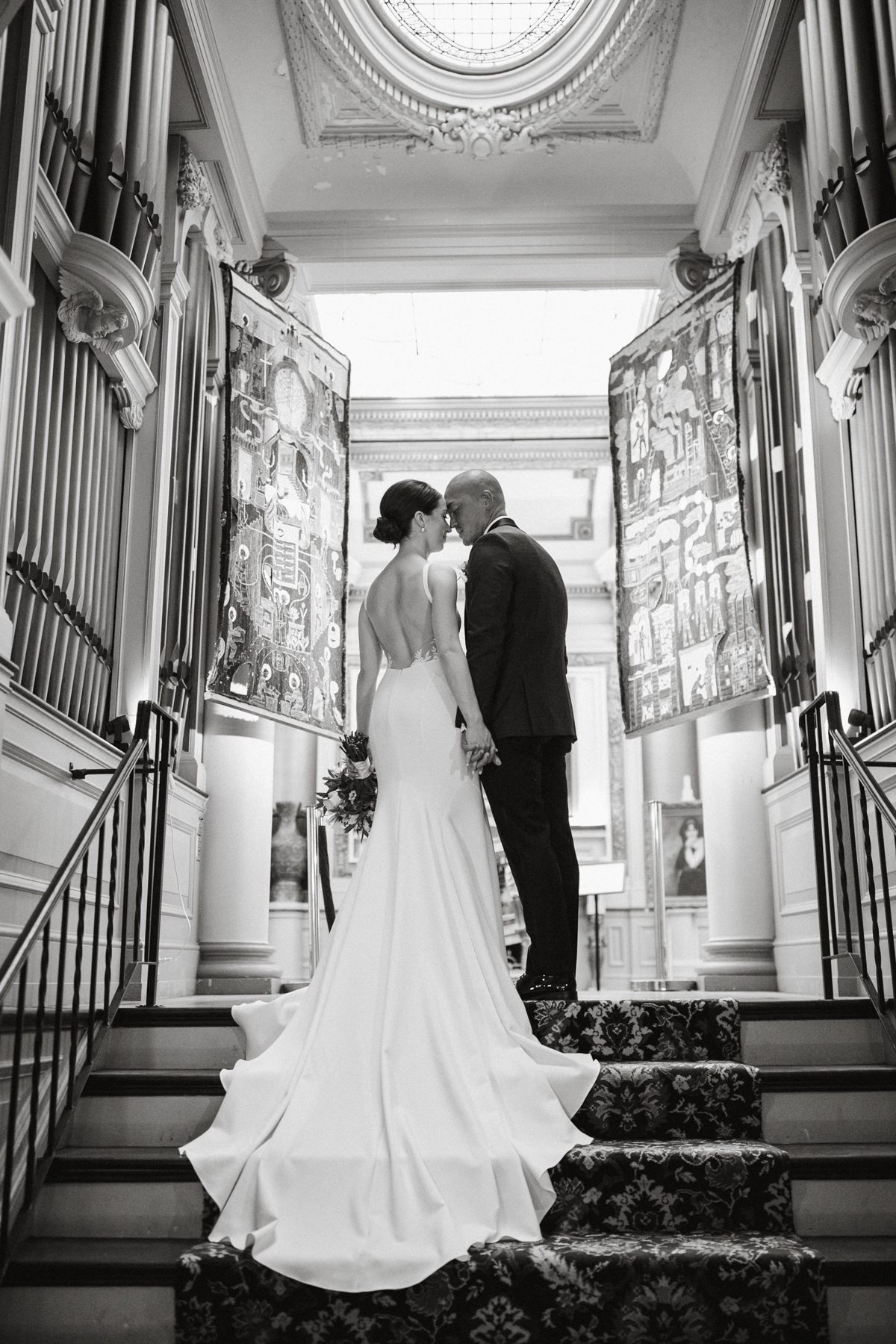 Bride and groom holding hands in mansion hallway – Philadelphia mansion wedding venue