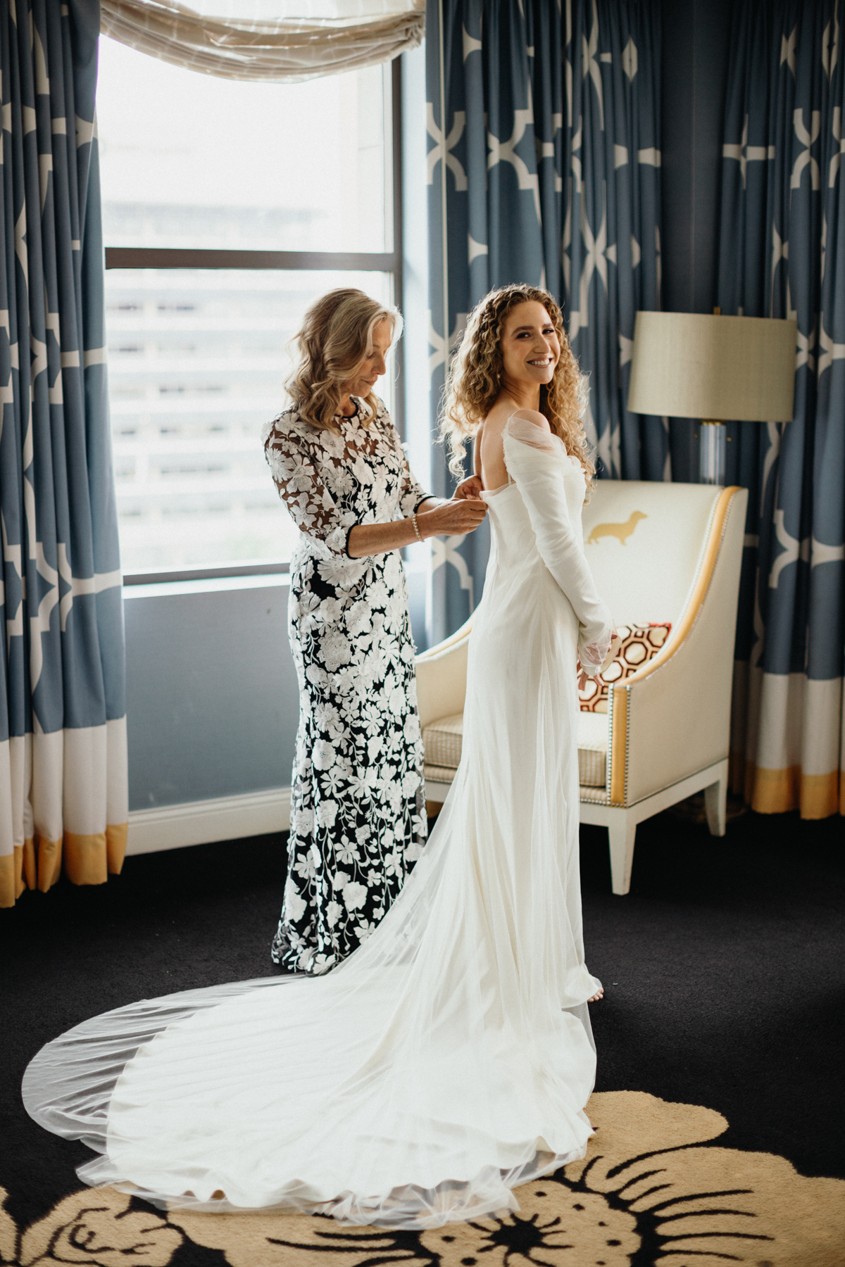 Bride zipping up her gown with help from her mom – Philadelphia wedding photographer.