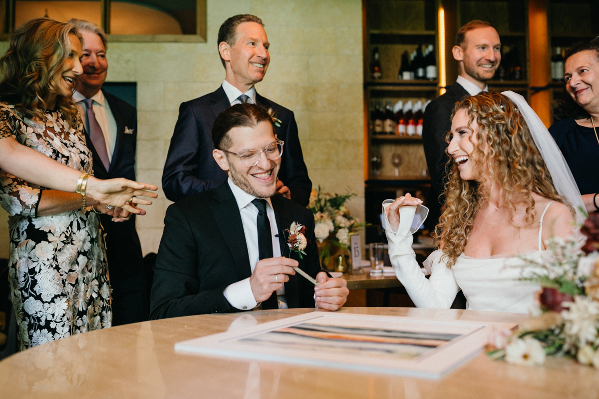 Couple seated with friends during ketubah signing – Candid photography, Philadelphia wedding