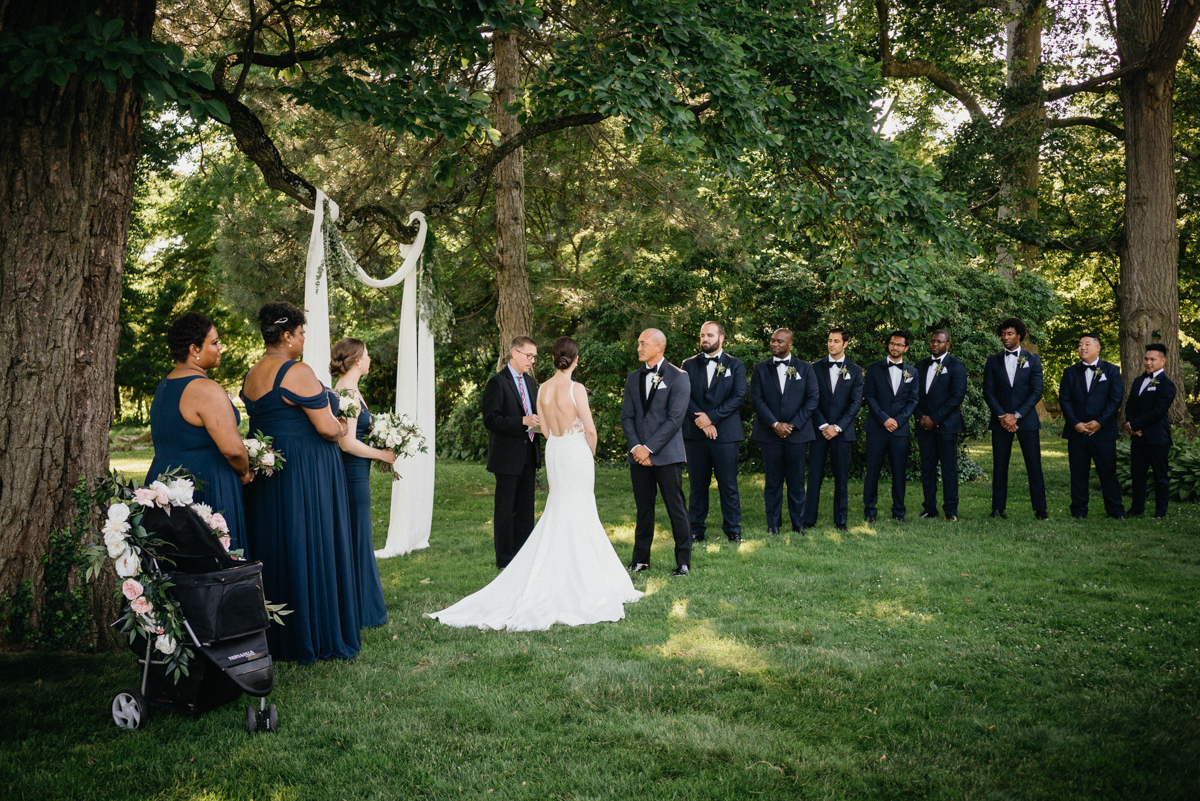 Officiant with couple near river – natural wedding photographer
