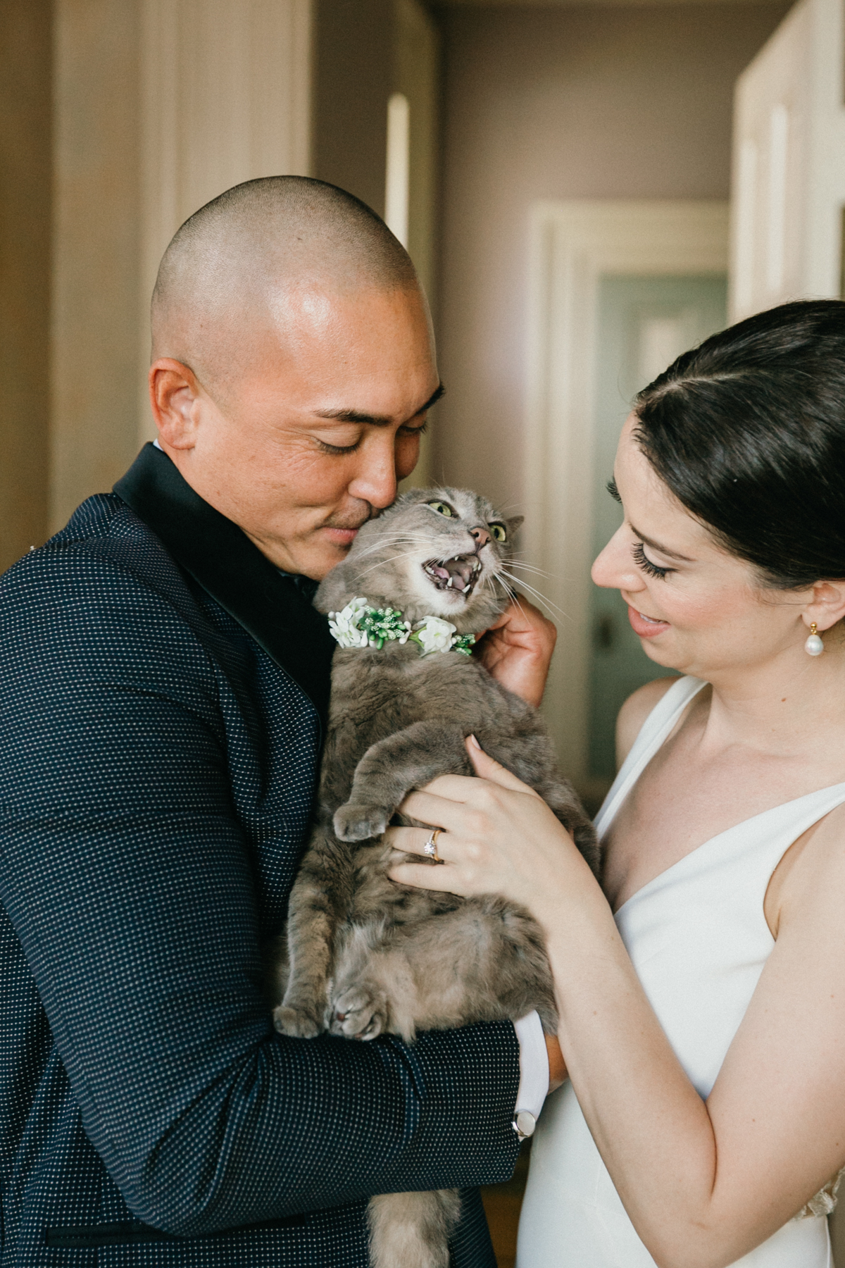 Candid moment of groom petting cat in bridal suite – cat in wedding at Glen Foerd Mansion