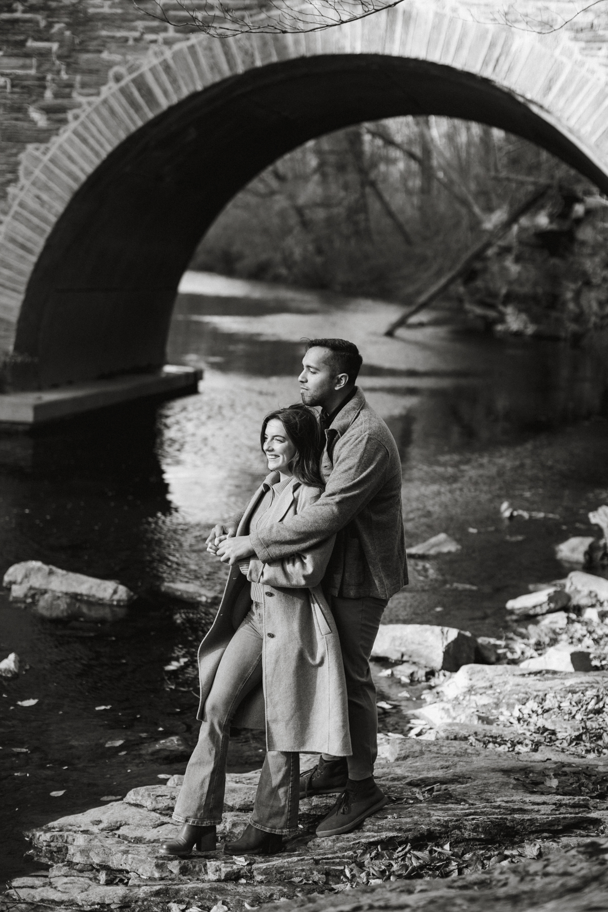 Couple standing near stone bridge in Wissahickon Valley Park