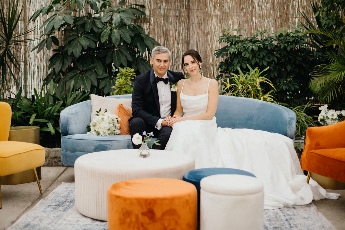 Full-body portrait of the couple framed by rental furniture