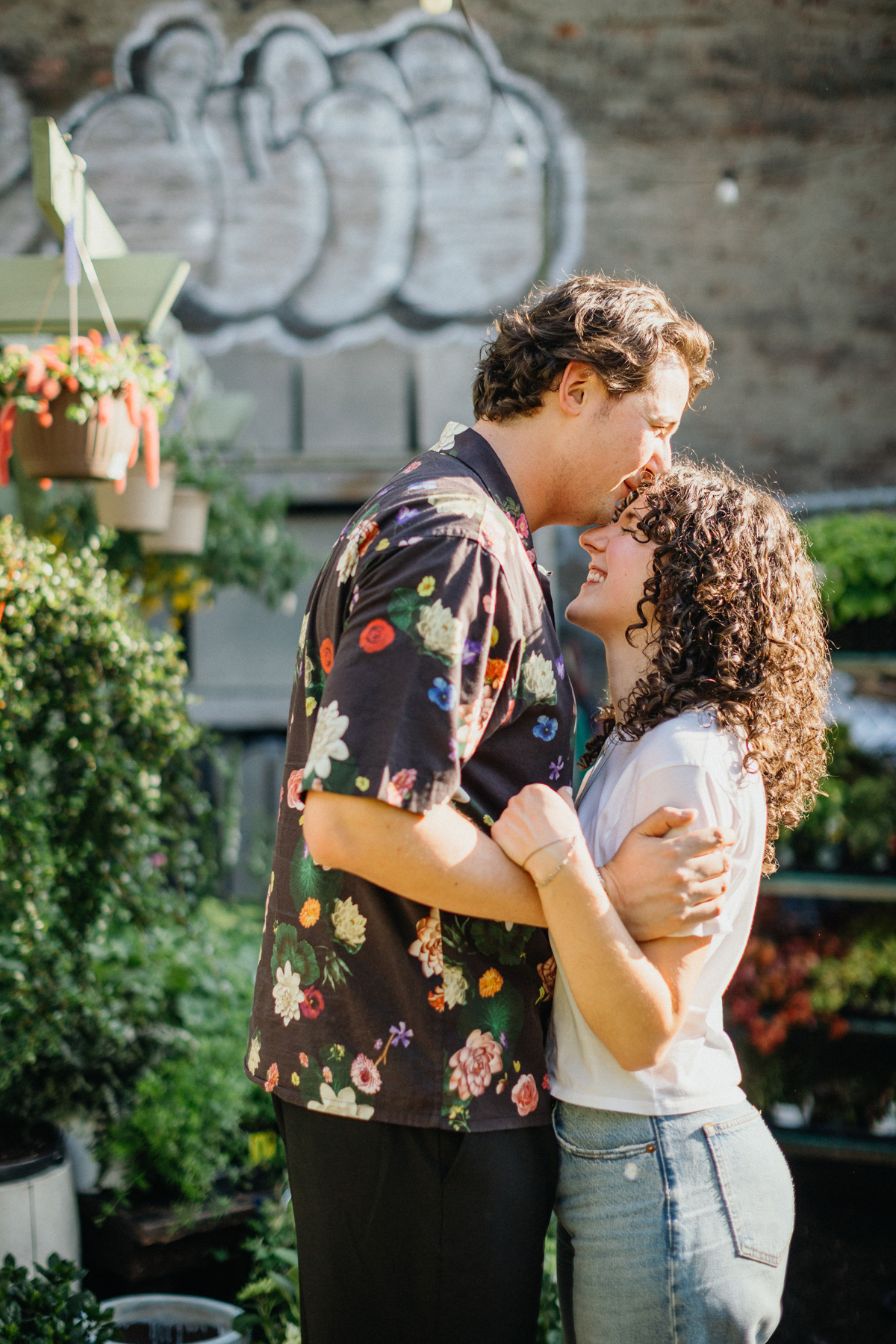 Stylish couple in Brooklyn engagement session, with vibrant murals in the background.