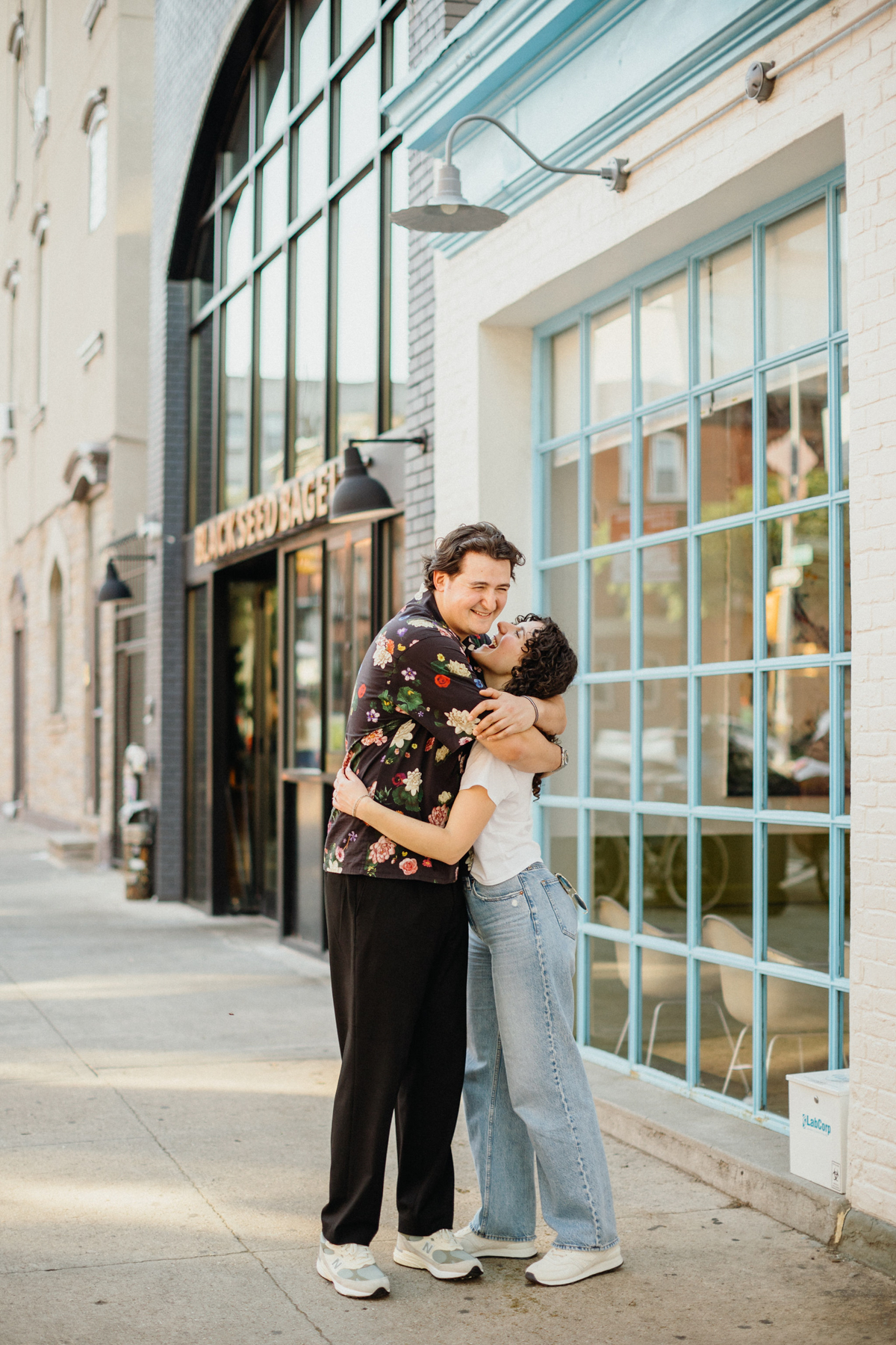 Engagement photos on film of the couple walking hand in hand through Brooklyn’s vibrant streets.