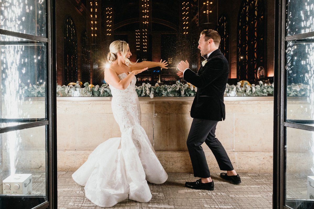 Bride and groom cheering from the balcony at their Union Trust wedding
