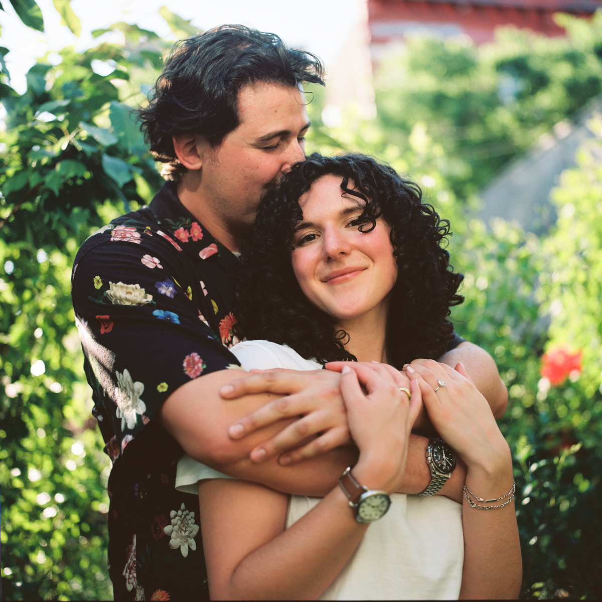 Engagement photos on film of Dylan and Olivia walking through a Brooklyn garden.