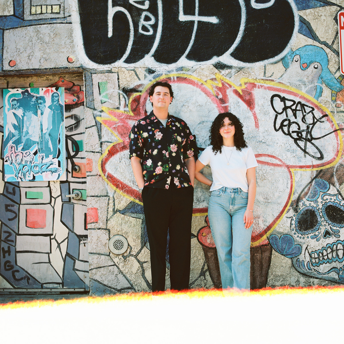 Engagement photos on film of a couple enjoying a walk through Brooklyn's colorful streets.