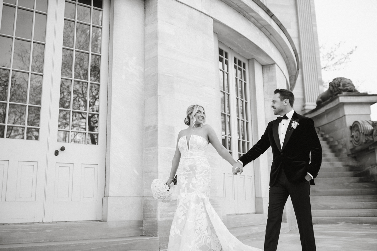Couple holding hands outside the Merchants’ Exchange on their Union Trust wedding day