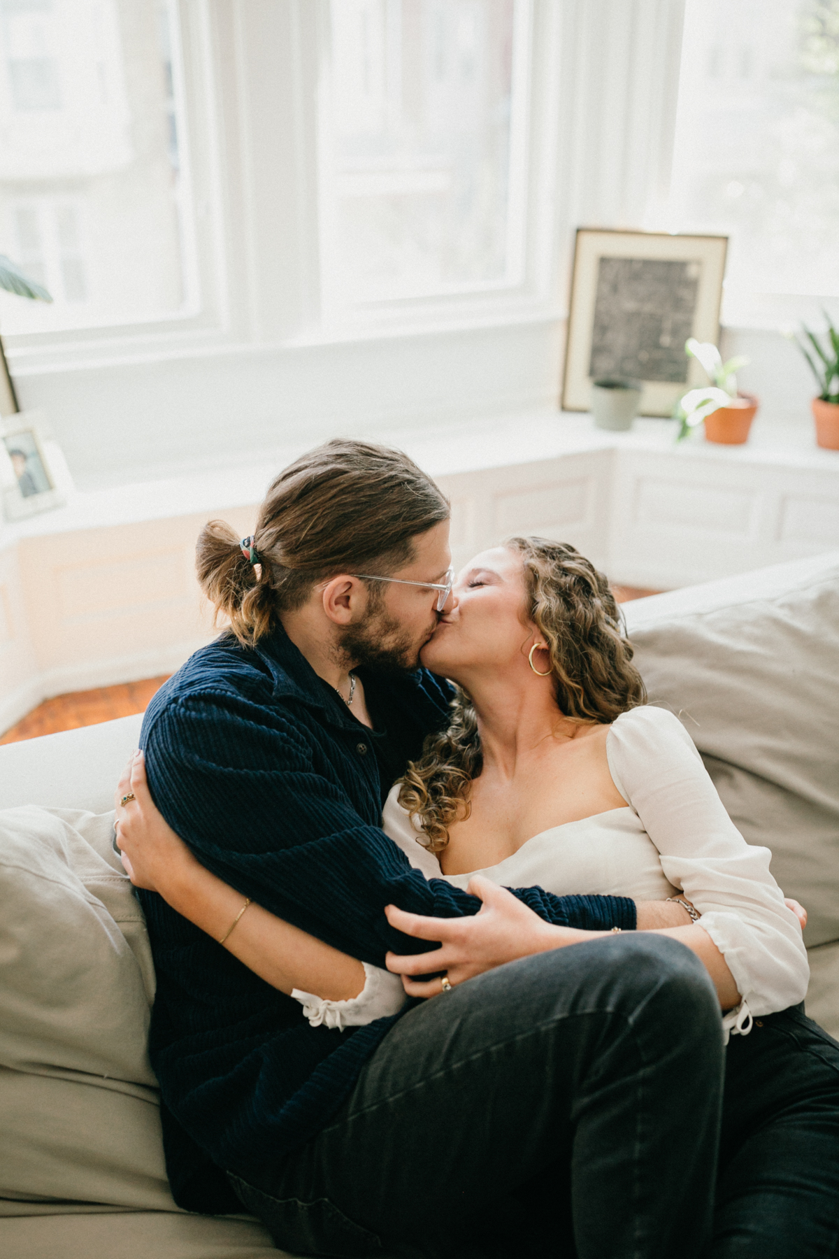 Relaxed portrait of couple seated on couch during at home engagement session