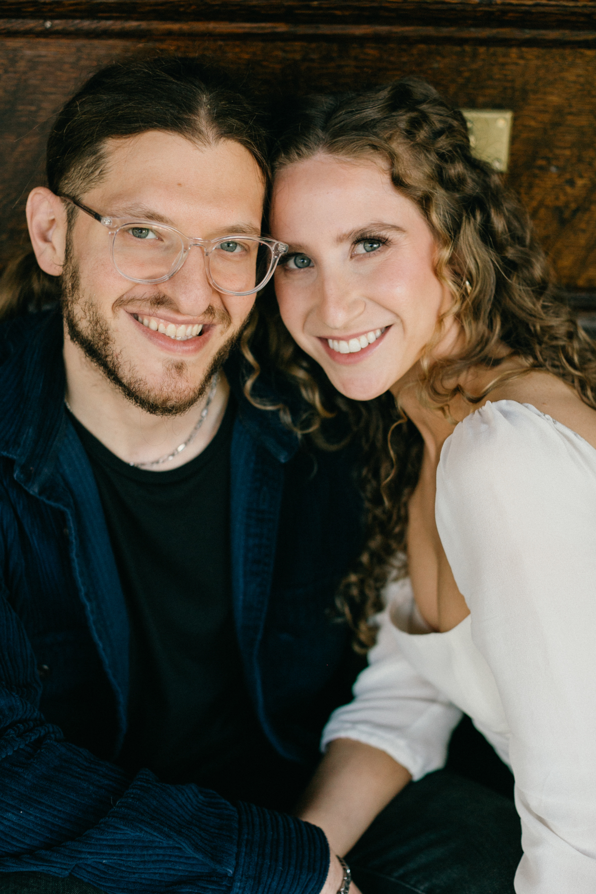 Soft indoor portrait during at home engagement session with couple smiling