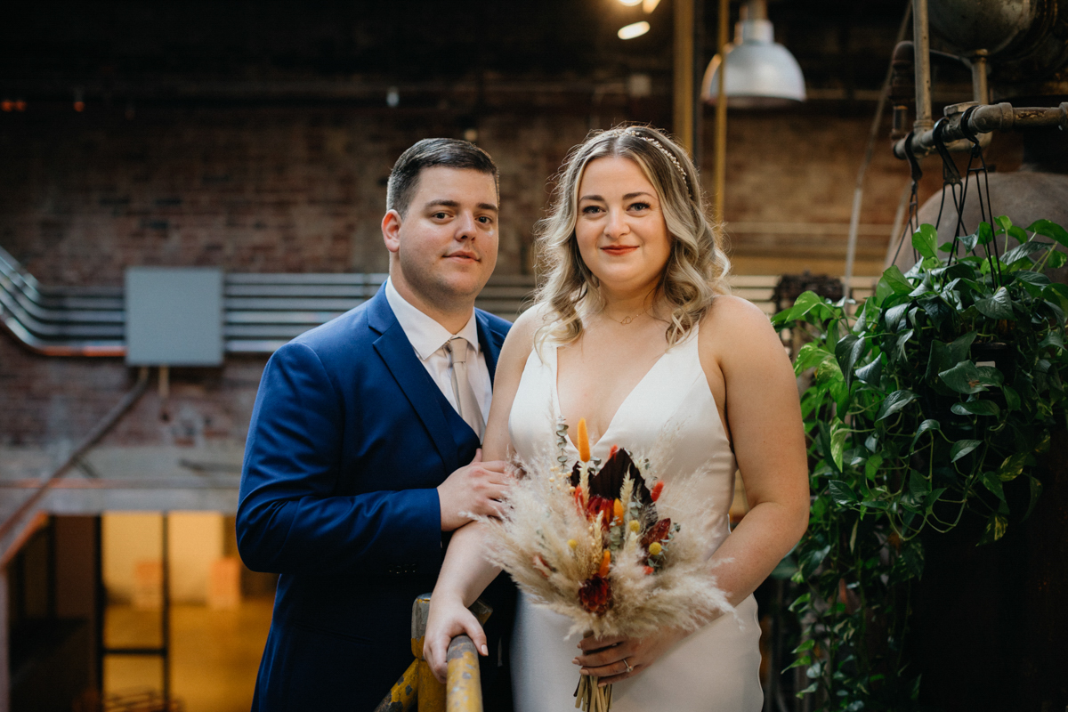 Bride and groom portraits in industrial interior with fall lighting