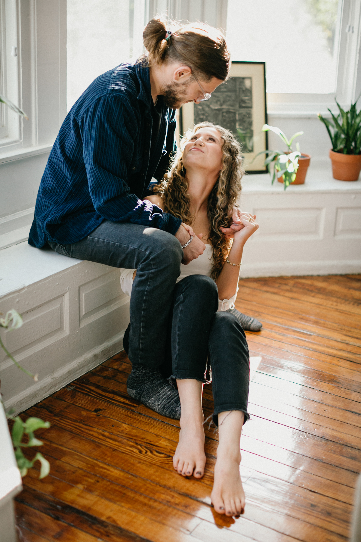 Natural indoor couples photo with soft backlighting and genuine expressions