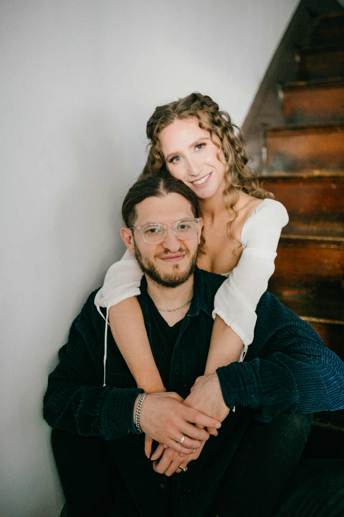 At home engagement photo with close-up portrait of couple holding each other