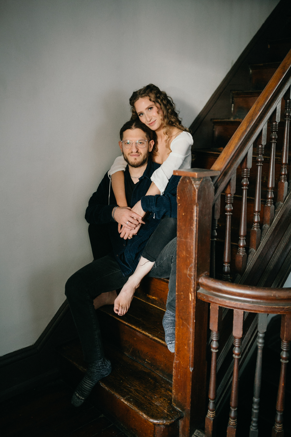 Indoor couples photo of playful moment on the staircase landing