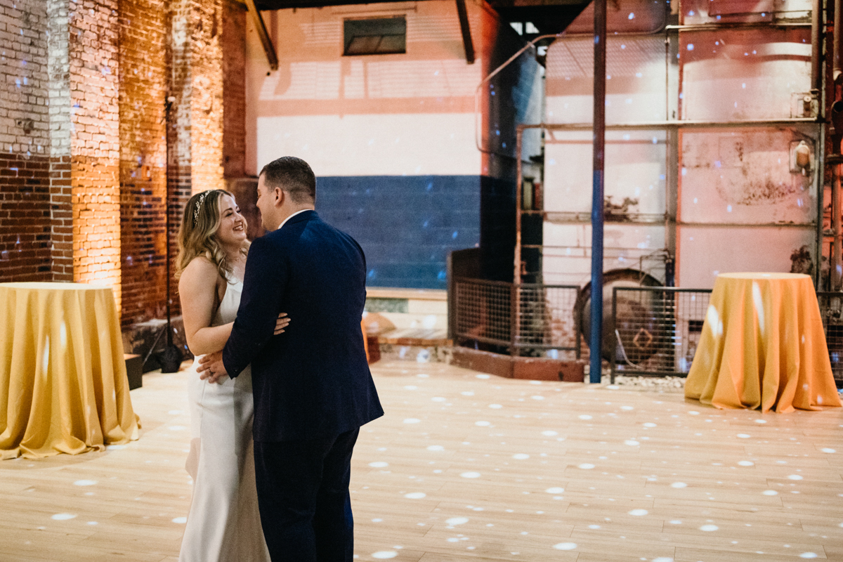 Bride and groom share first dance surrounded by industrial textures