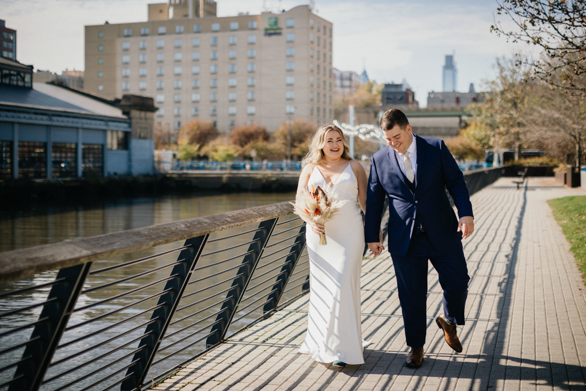 Philly wedding photographer documents couple walking by the river